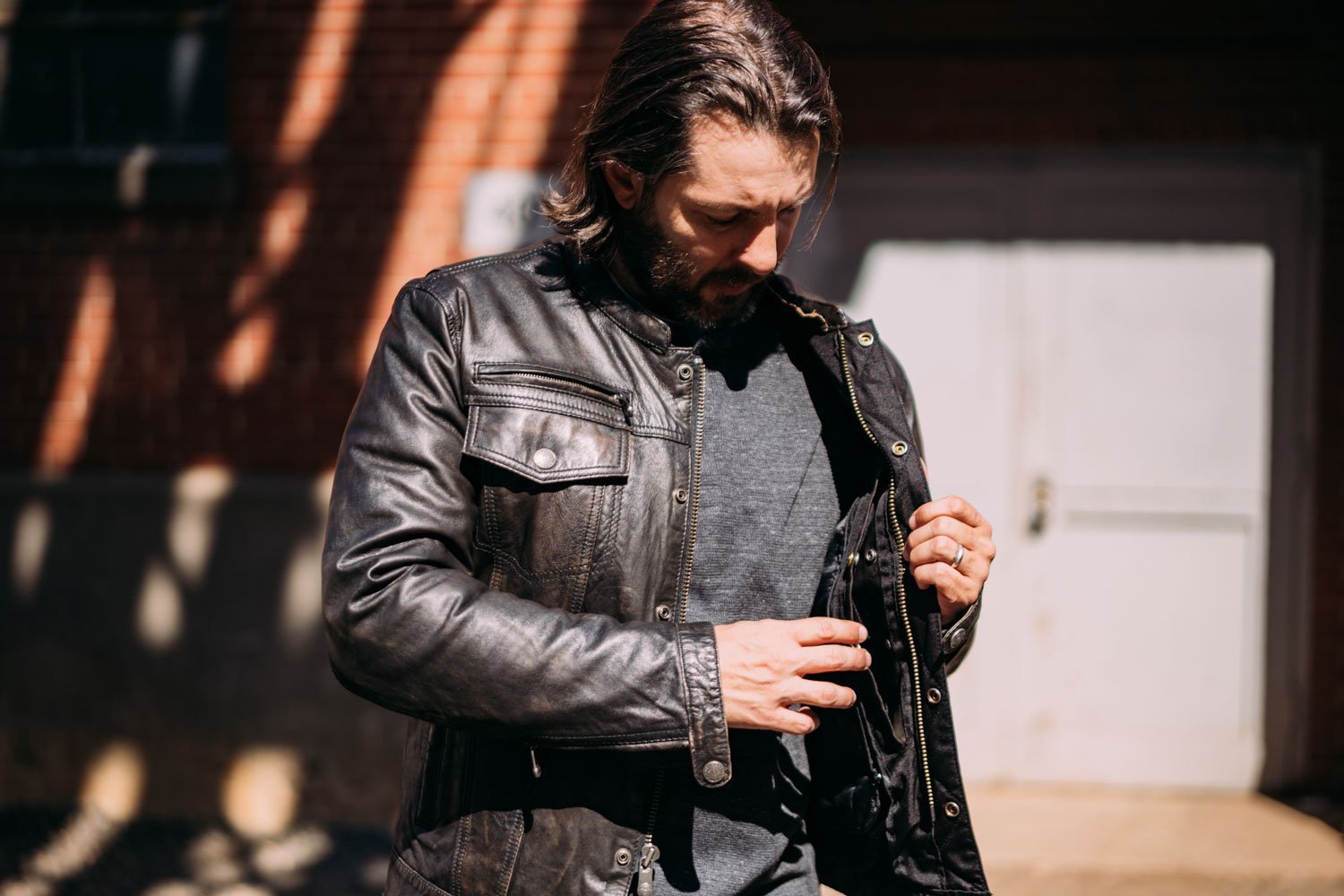 Vendetta Men's Leather Motorcycle Jacket featuring a stylish scooter design, multiple pockets, and a removable hood.