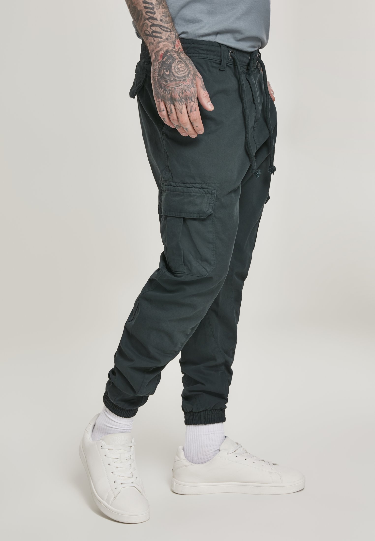 A pair of stylish cargo jogging pants made from 100% cotton, featuring multiple pockets and an elastic waistband for comfort.