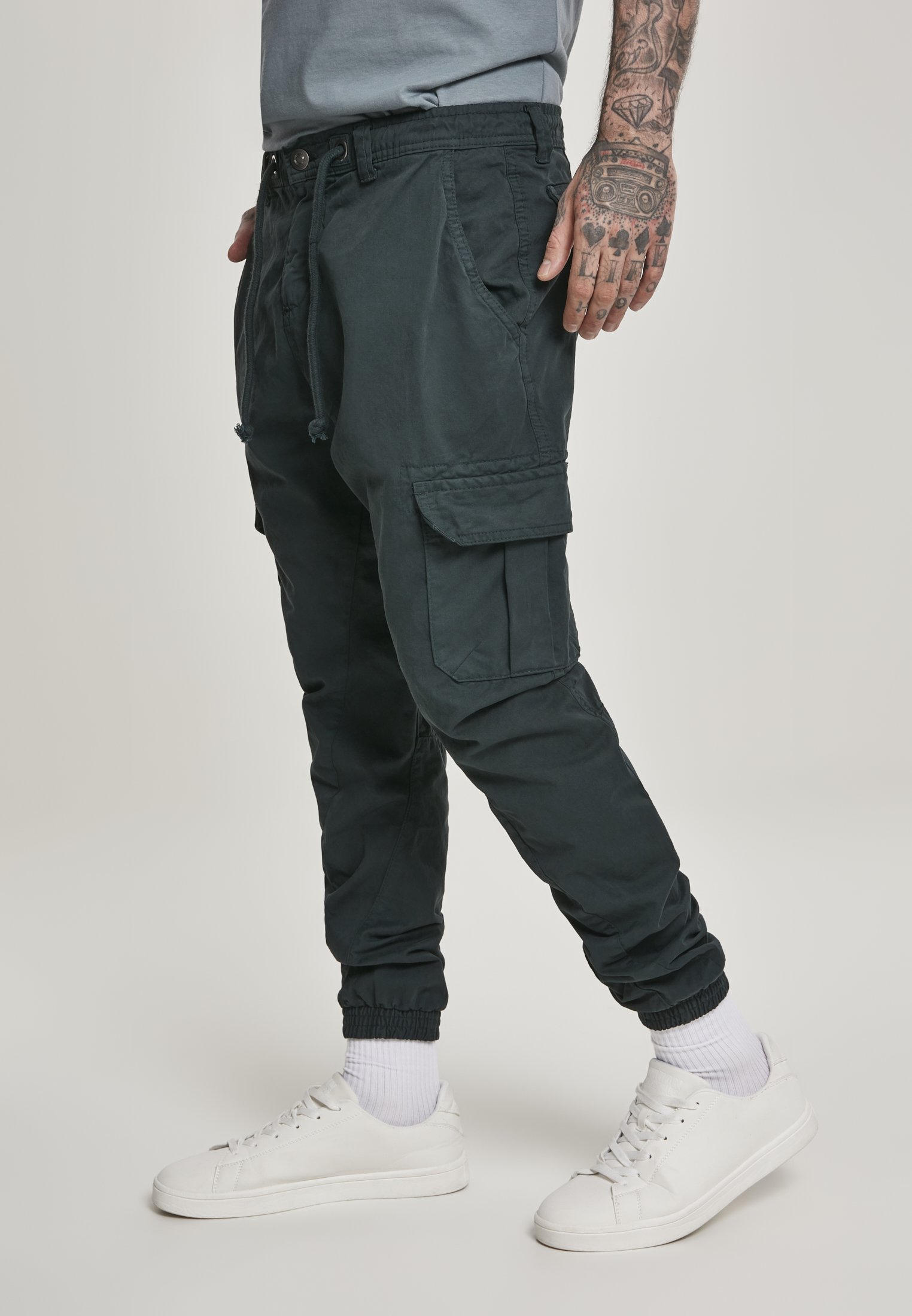 A pair of stylish cargo jogging pants made from 100% cotton, featuring multiple pockets and an elastic waistband for comfort.