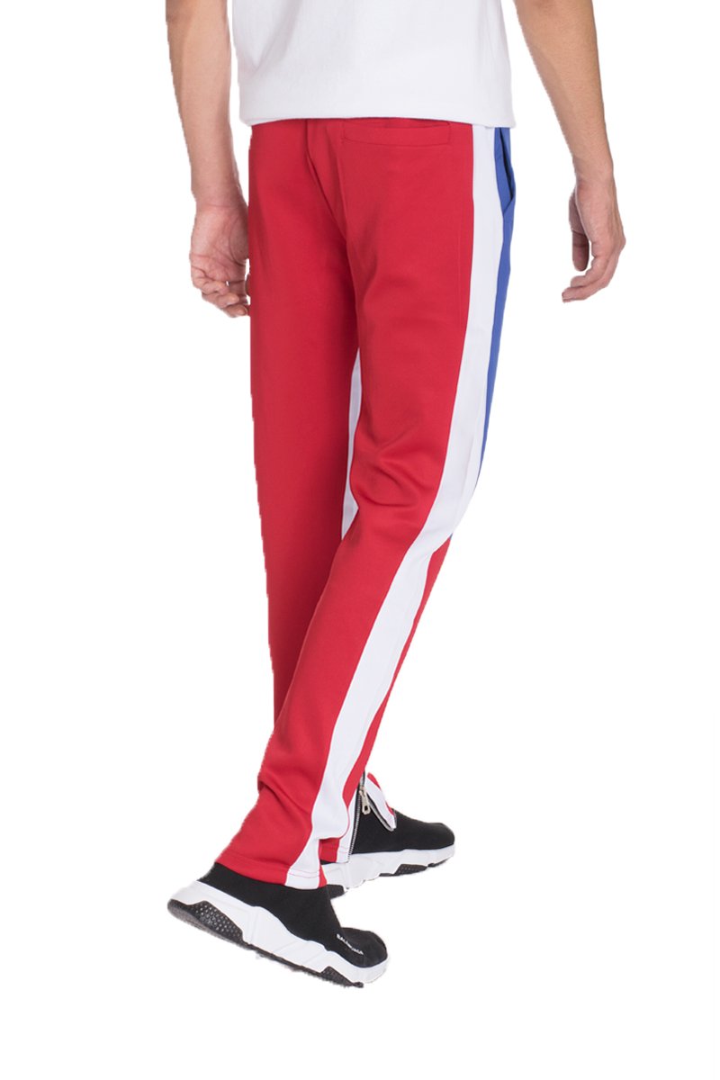 A pair of stylish color block track pants featuring a regular fit, standard pockets, and hidden ankle zippers, displayed on a model.