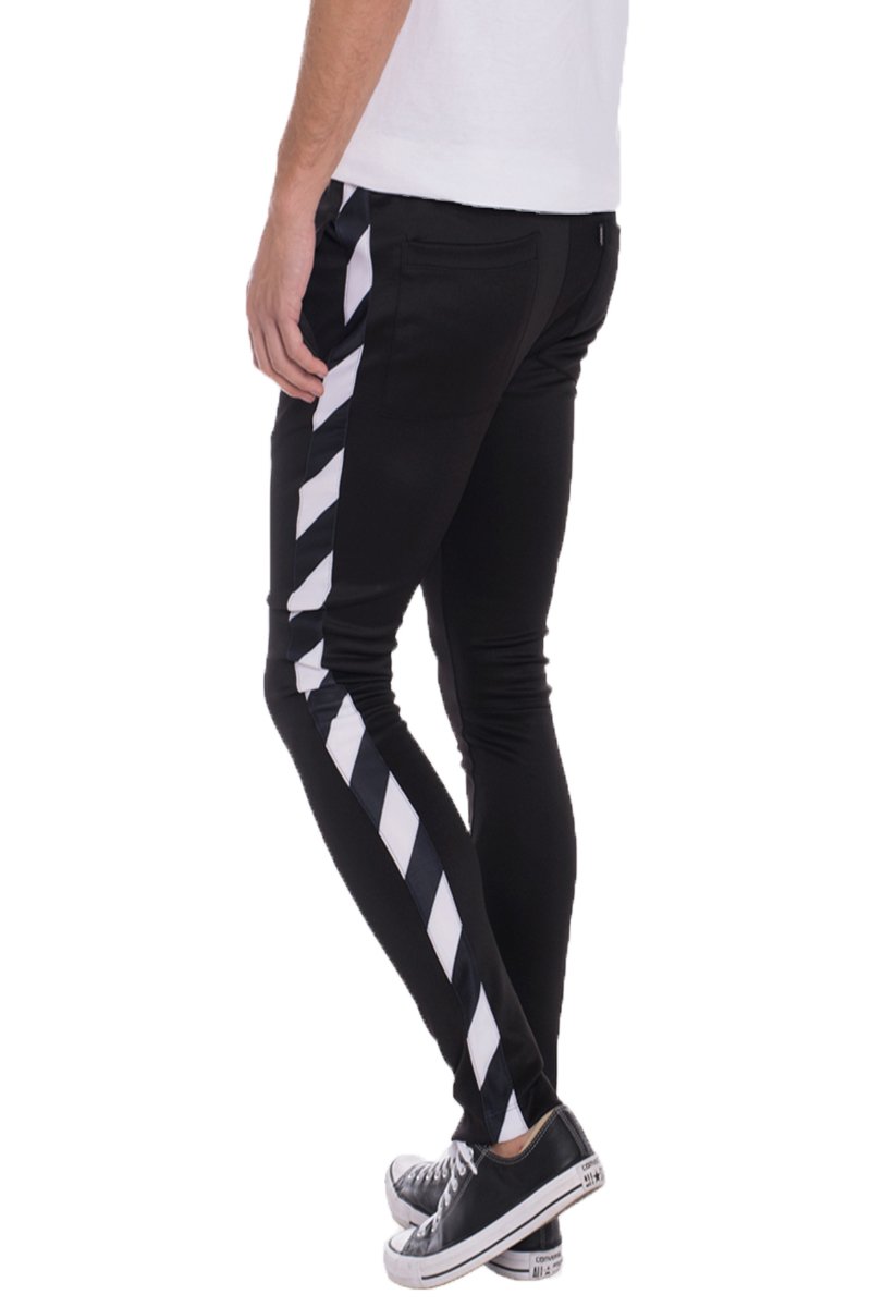 A pair of solid black Diagonal Track Pants featuring a diagonal stripe print on the side, showcasing a skinny fit and elastic waist with drawstring.