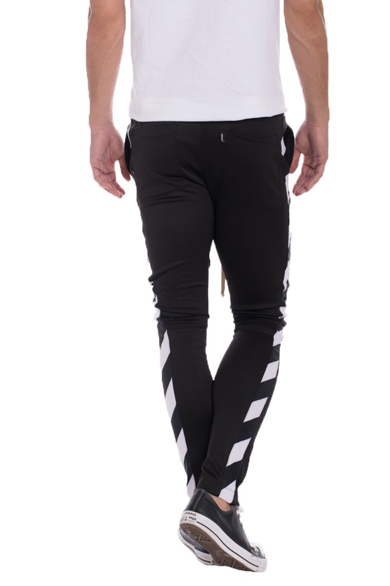 A pair of solid black Diagonal Track Pants featuring a diagonal stripe print on the side, showcasing a skinny fit and elastic waist with drawstring.