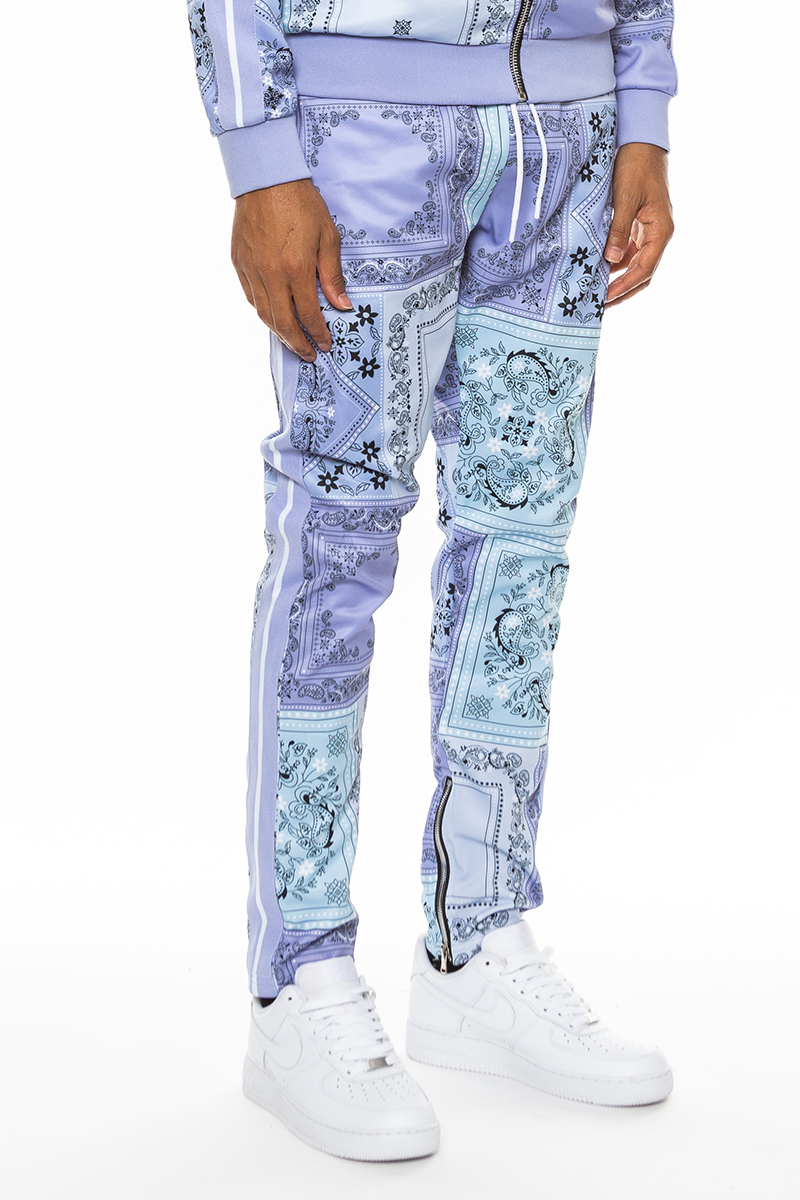 A pair of stylish paisley all over print pants featuring an elastic waist, drawstring, standard pockets, and ankle zippers.