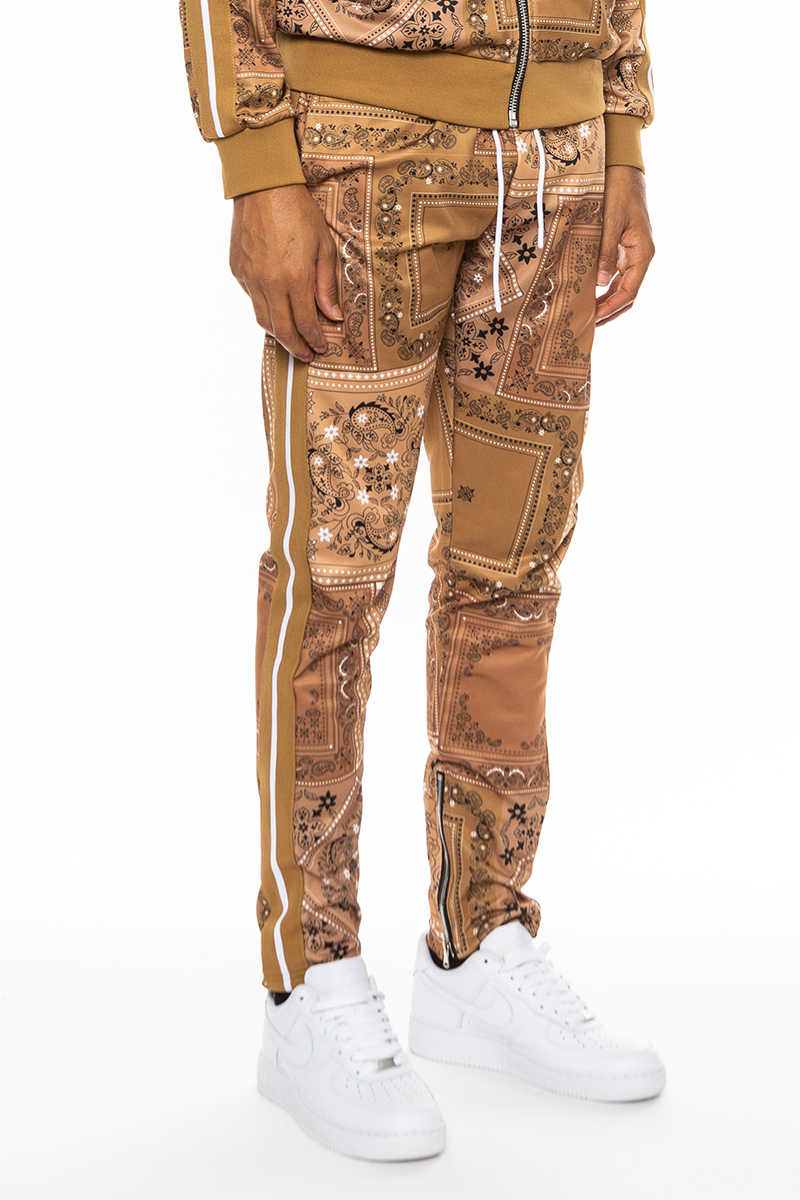 A pair of stylish paisley all over print pants featuring an elastic waist, drawstring, standard pockets, and ankle zippers.