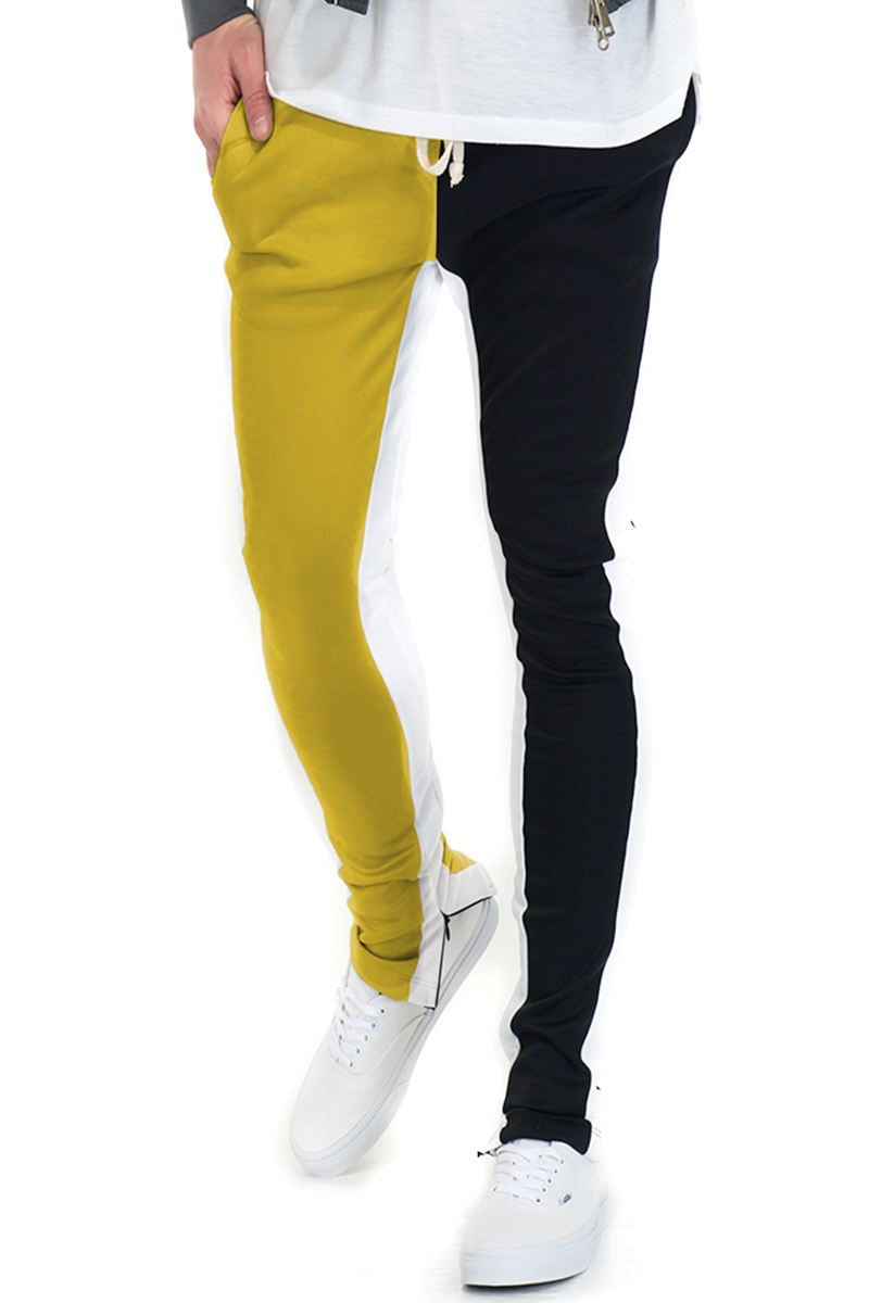 SLICE TRACK PANTS in black and yellow with elastic waist, drawstring, and hidden ankle zipper, perfect for active lifestyles.