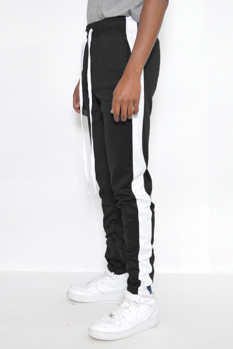 A pair of black and white slim fit track pants featuring hidden ankle zippers and standard pockets, designed for comfort and style.