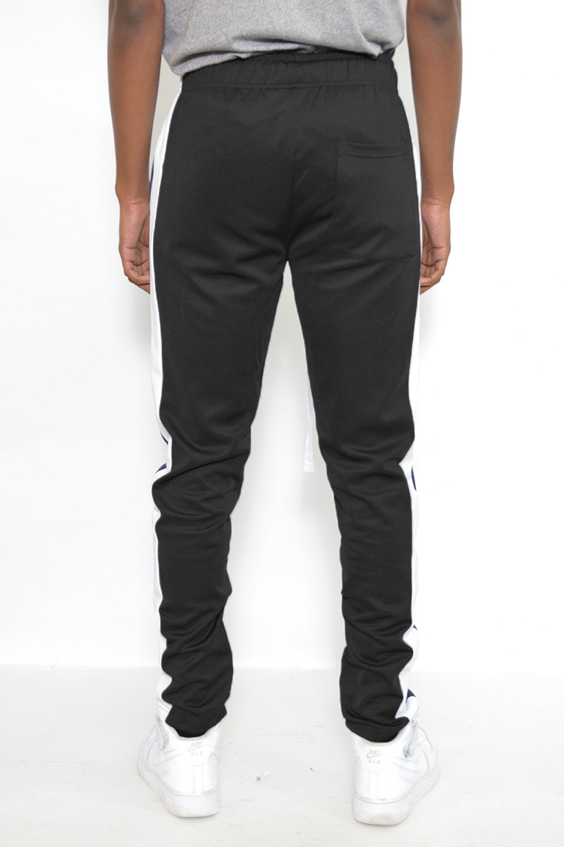 A pair of black and white slim fit track pants featuring hidden ankle zippers and standard pockets, designed for comfort and style.