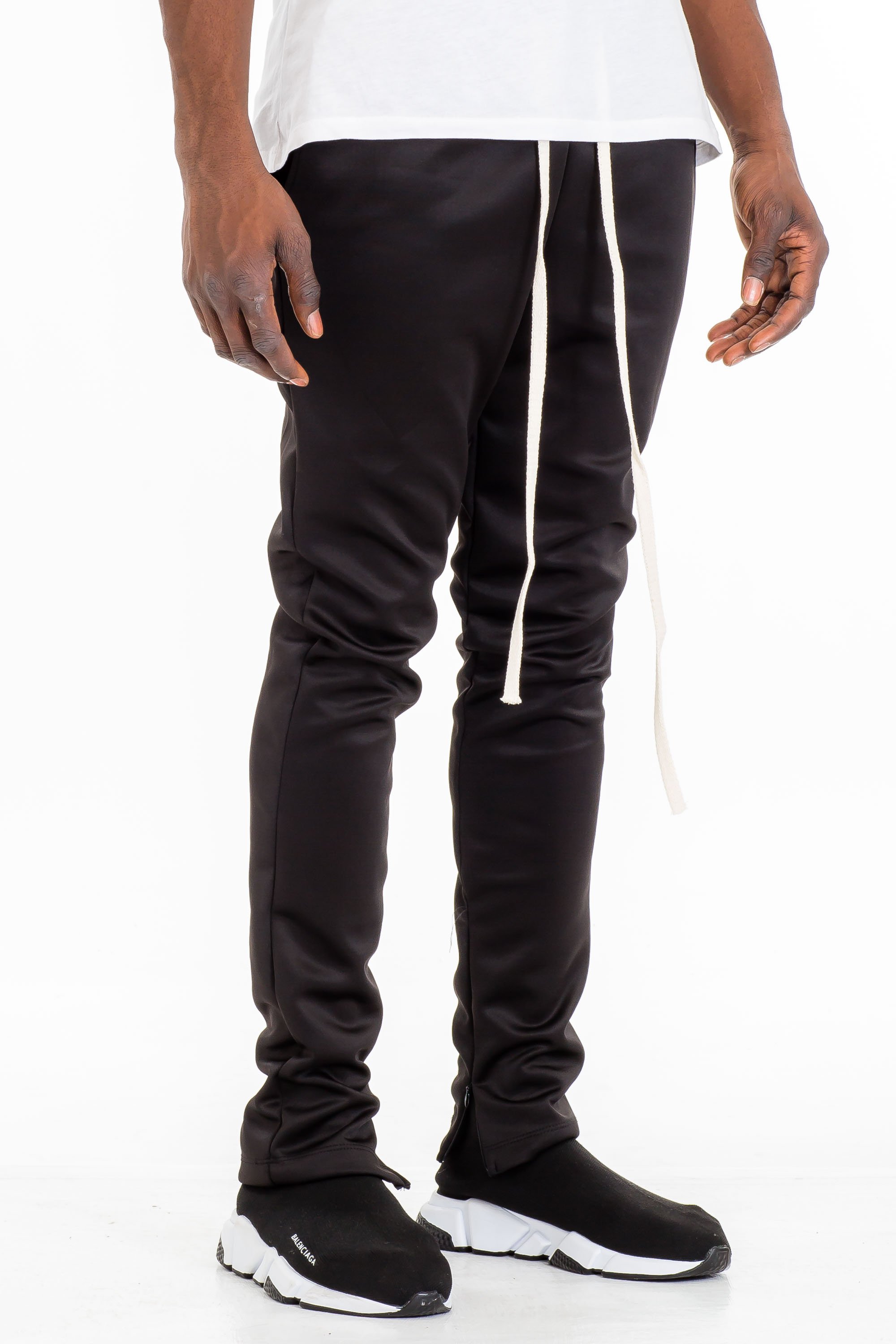 A pair of stylish solid track pants featuring a skinny fit, elastic waist with drawstring, and hidden ankle zippers, displayed on a neutral background.