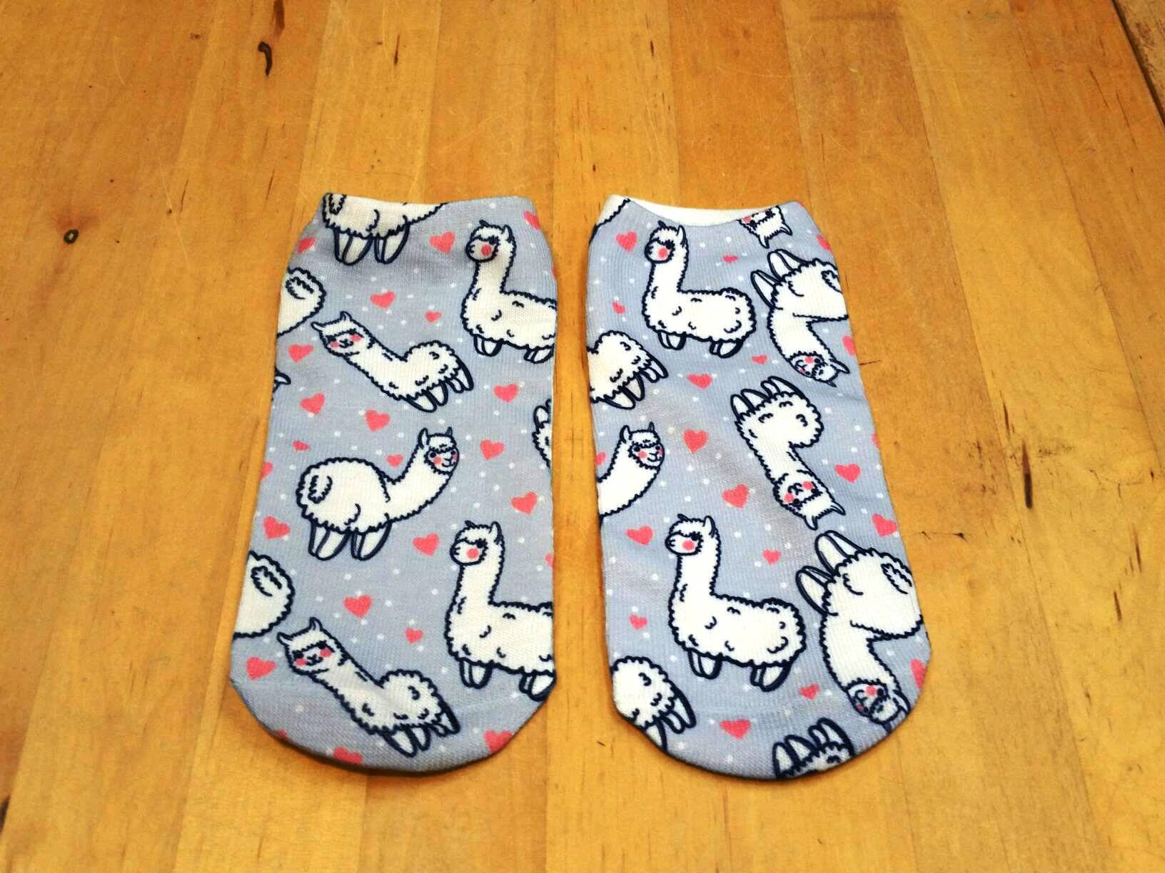 A pair of cute Alpaca Dreams of Love socks featuring an adorable alpaca design, made from a soft cotton/polyester blend, suitable for women and kids.