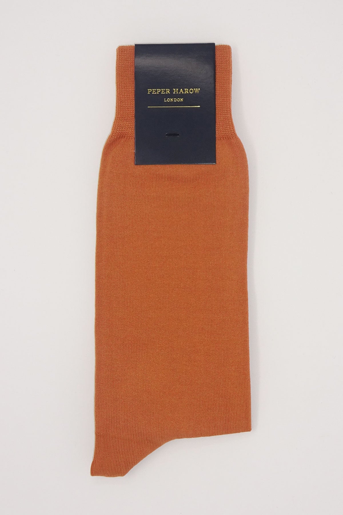 A pair of classic men's socks in burnt orange, made from Mercerised Egyptian cotton, showcasing a seamless toe design.