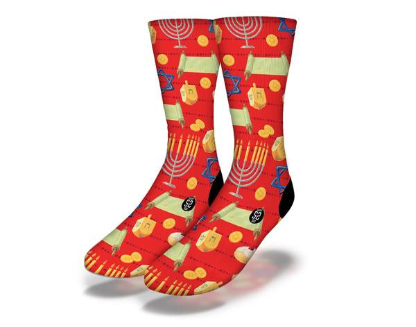 A pair of vibrant red Hanukkah socks featuring traditional Judaica symbols like the menorah, dreidel, and Star of David.