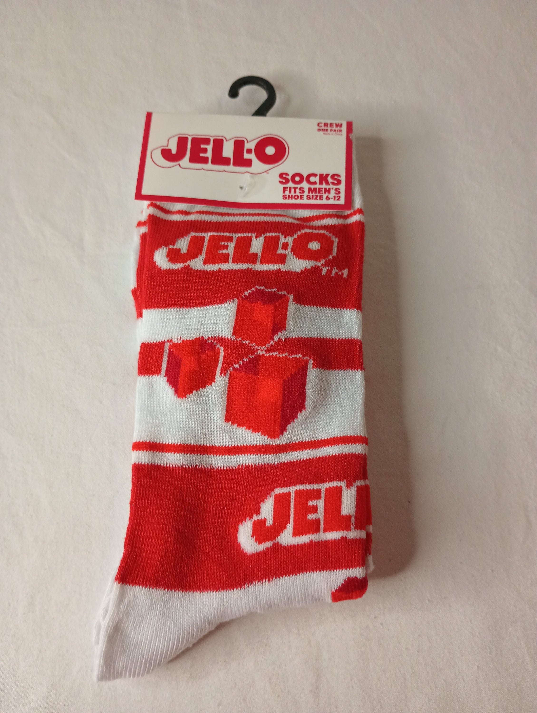 A pair of vibrant red and white Jell-O Crew Socks designed for men, showcasing a playful dessert-inspired pattern.