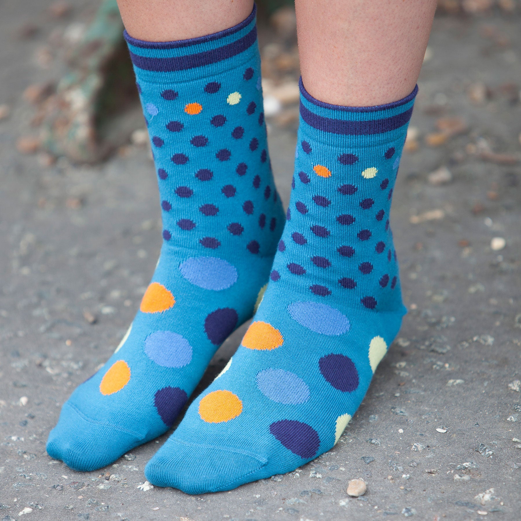 Colorful Mary Women's Socks featuring a peacock polka dot design in yellow, orange, navy, and blue, made from luxurious Supima cotton.