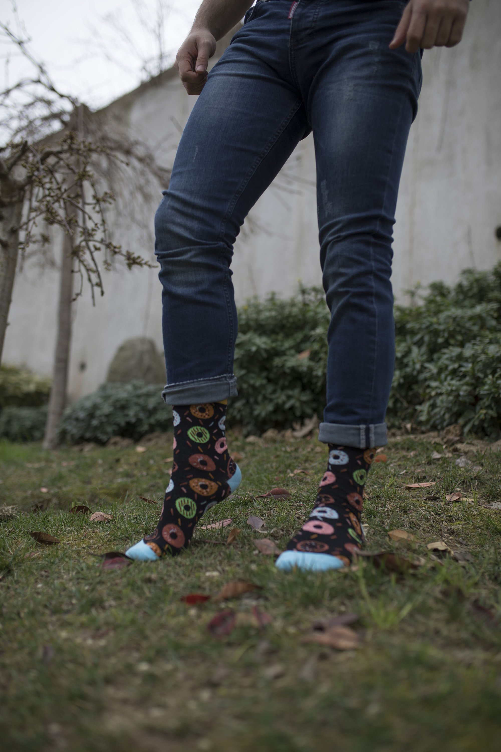 A pair of colorful men's socks featuring a playful donut pattern, made from soft combed cotton.