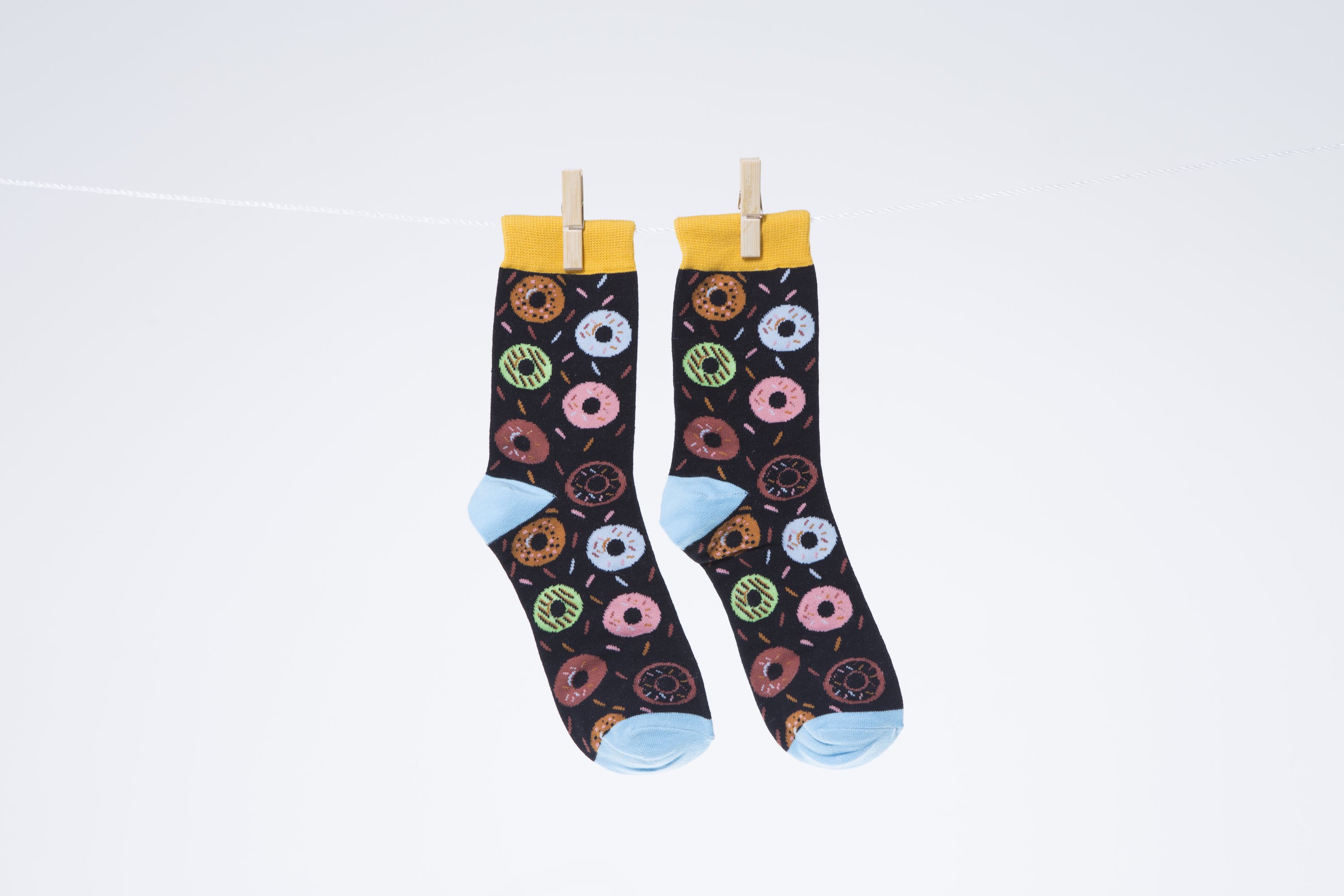 A pair of colorful men's socks featuring a playful donut pattern, made from soft combed cotton.