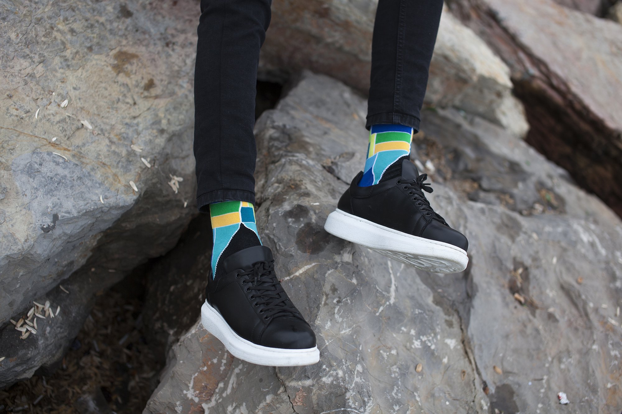 Person wearing colorful socks, black sneakers.