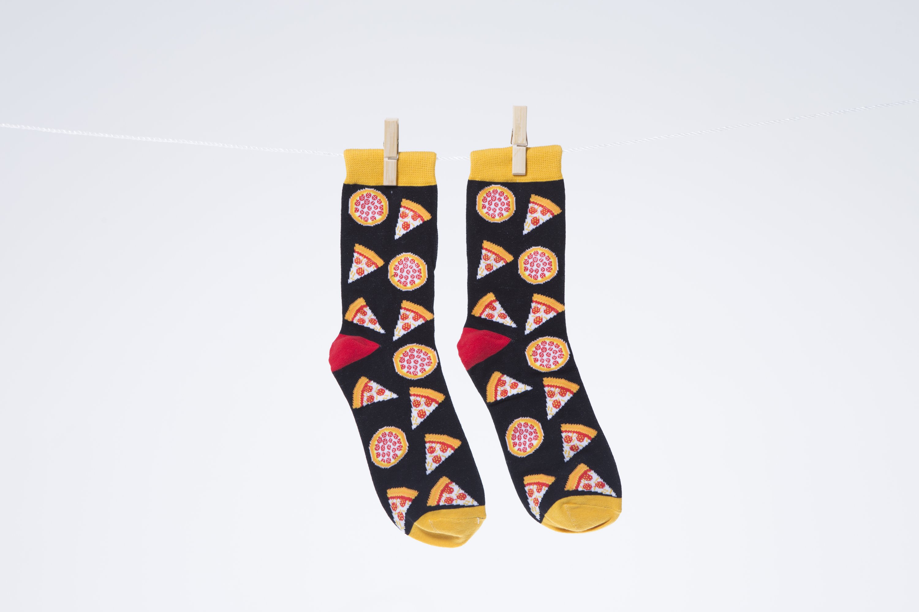 A pair of colorful men's socks featuring a fun pizza design, made from soft combed cotton.