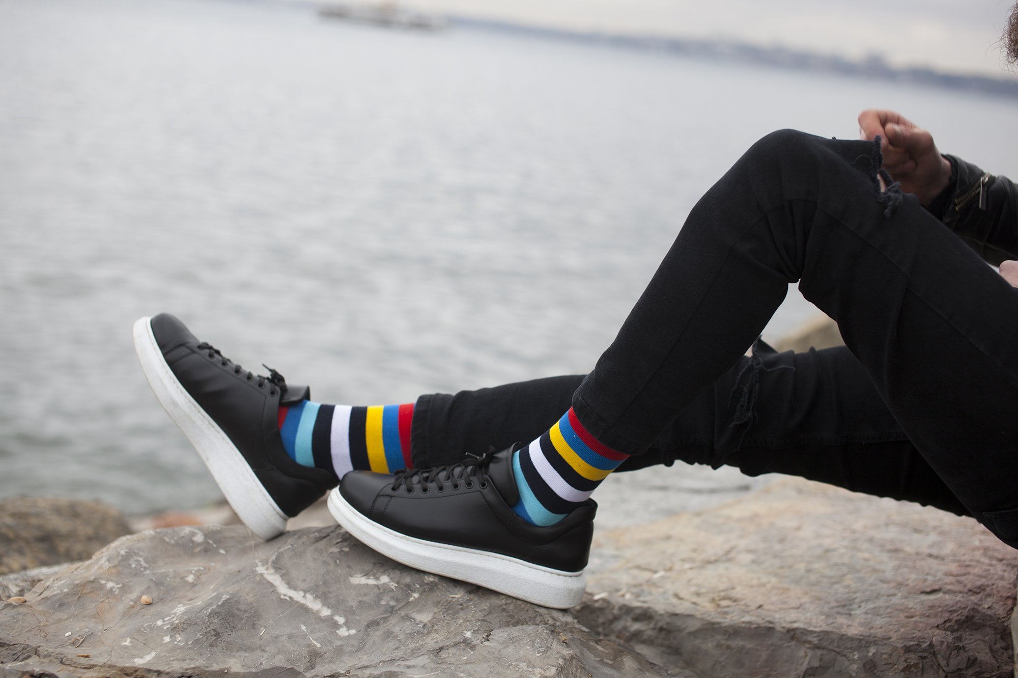 A collection of colorful men's striped socks displayed in a luxurious gift box, showcasing their trendy designs and premium quality.