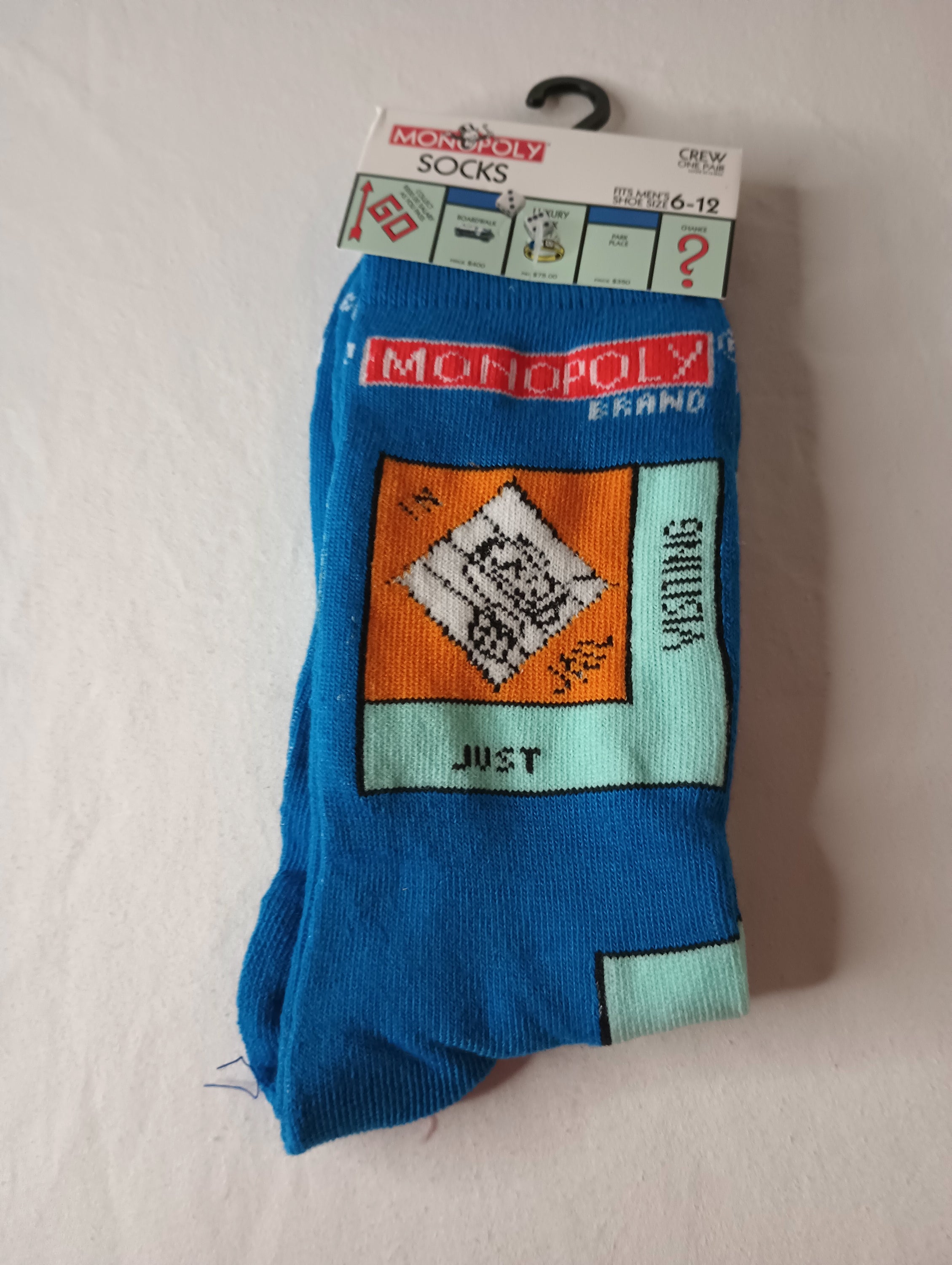 A pair of blue multi-color MONOPOLY Crew Socks designed for men, featuring a playful design inspired by the classic board game.