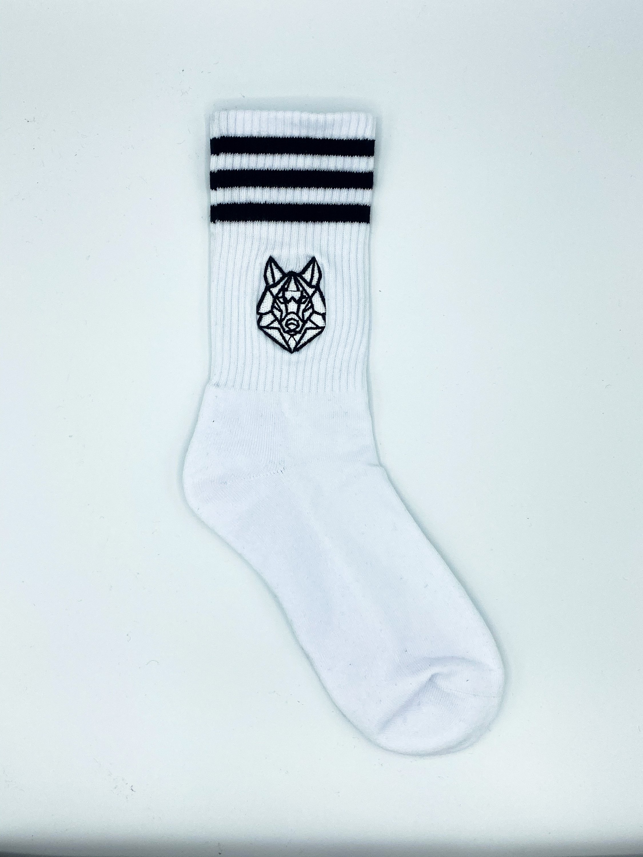 A pair of Omega White Crew Socks featuring ribbed cuffs, 3-Stripes design, and a half-cushioned footbed, displayed on a neutral background.