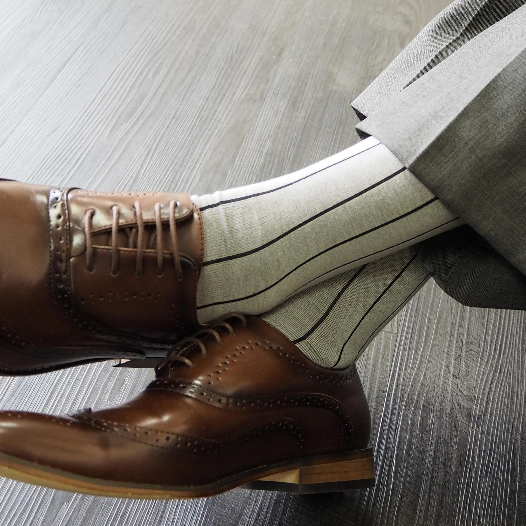 Luxury ash grey men's socks with black stripes and burgundy heel and toe, showcasing a seamless toe design.