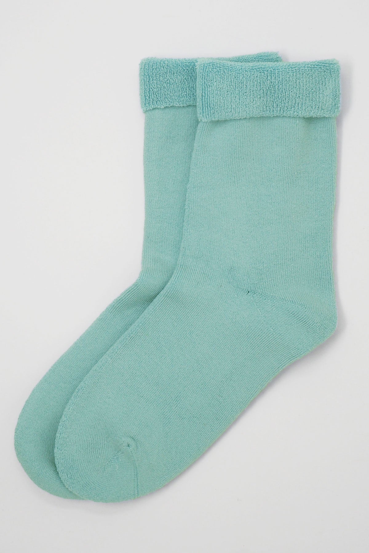 A pair of luxurious light blue men's bed socks made from Supima cotton, showcasing their fluffy interior and seamless toe design.