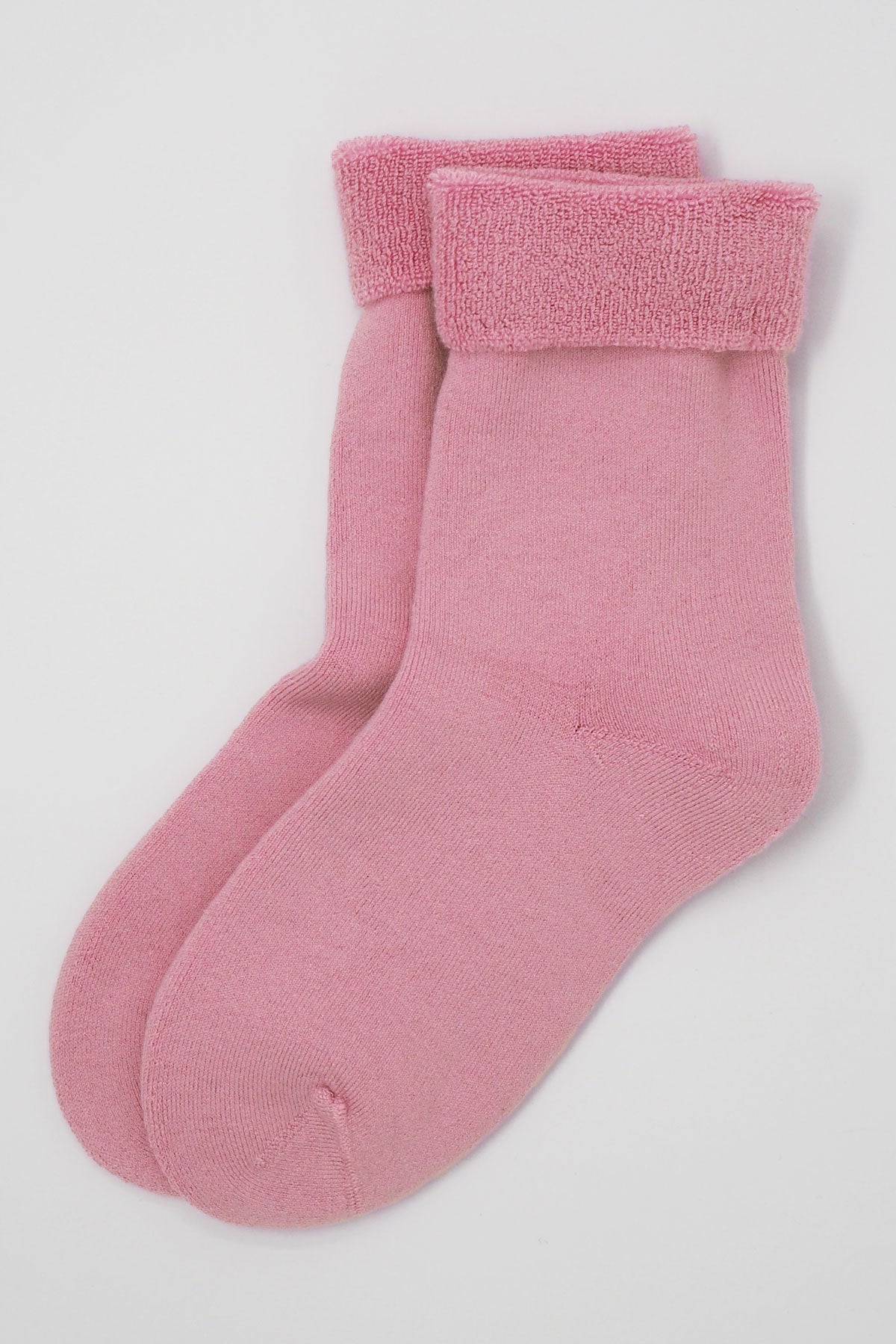 A pair of luxurious pink men's bed socks made from soft Supima cotton, showcasing their fluffy interior and seamless toe design.