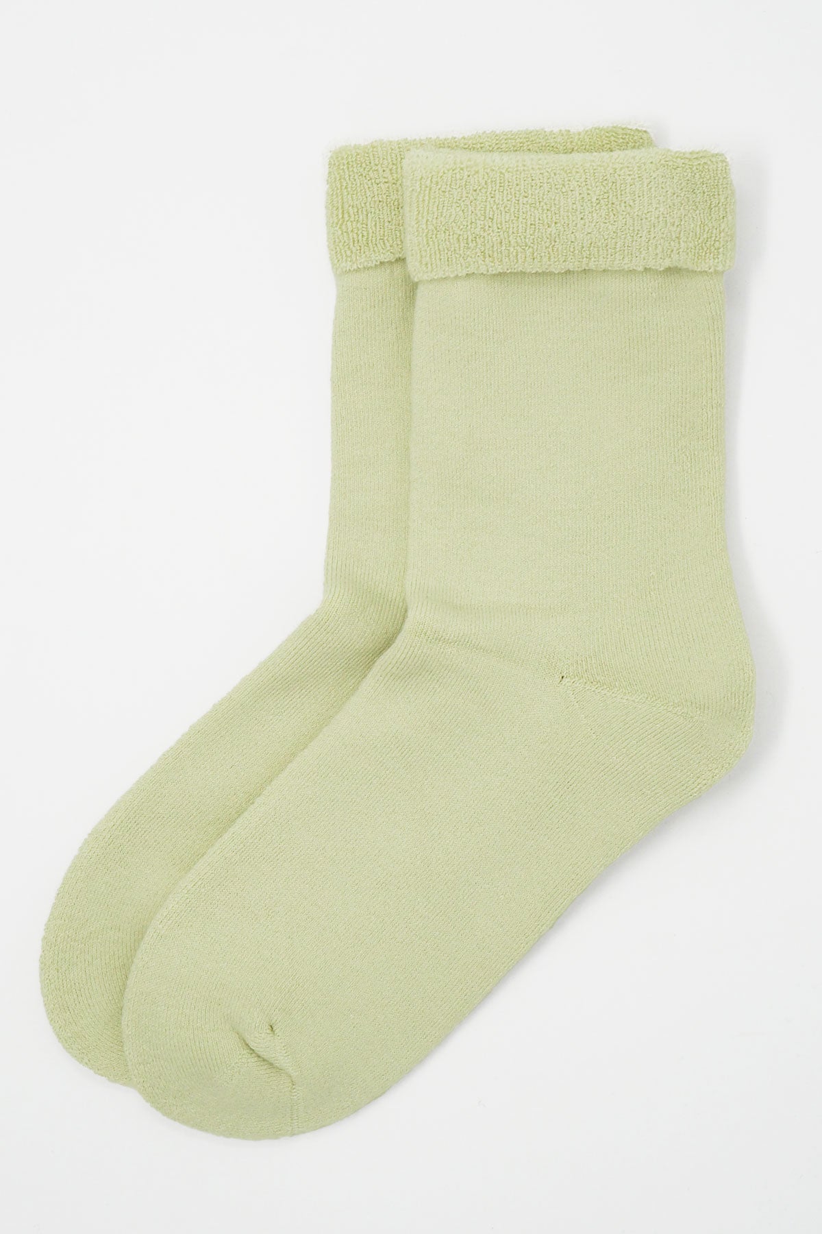 Cream colored women's bed socks made from luxurious Supima cotton, featuring a fluffy interior and seamless toe design for ultimate comfort.