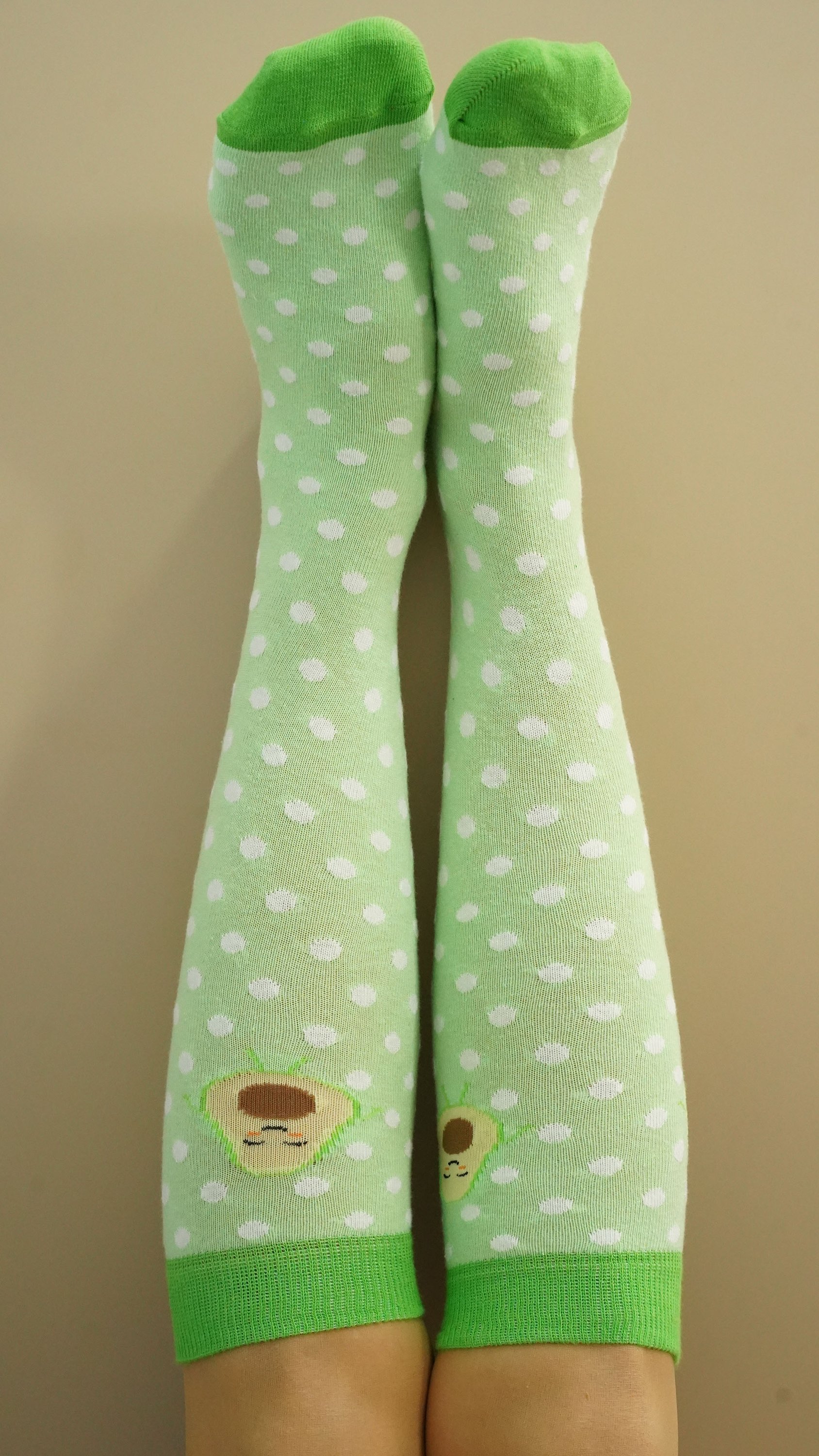 A pair of Women's Avocado Dot Knee High Socks featuring a colorful avocado dot pattern, perfect for adding a fun touch to any outfit.