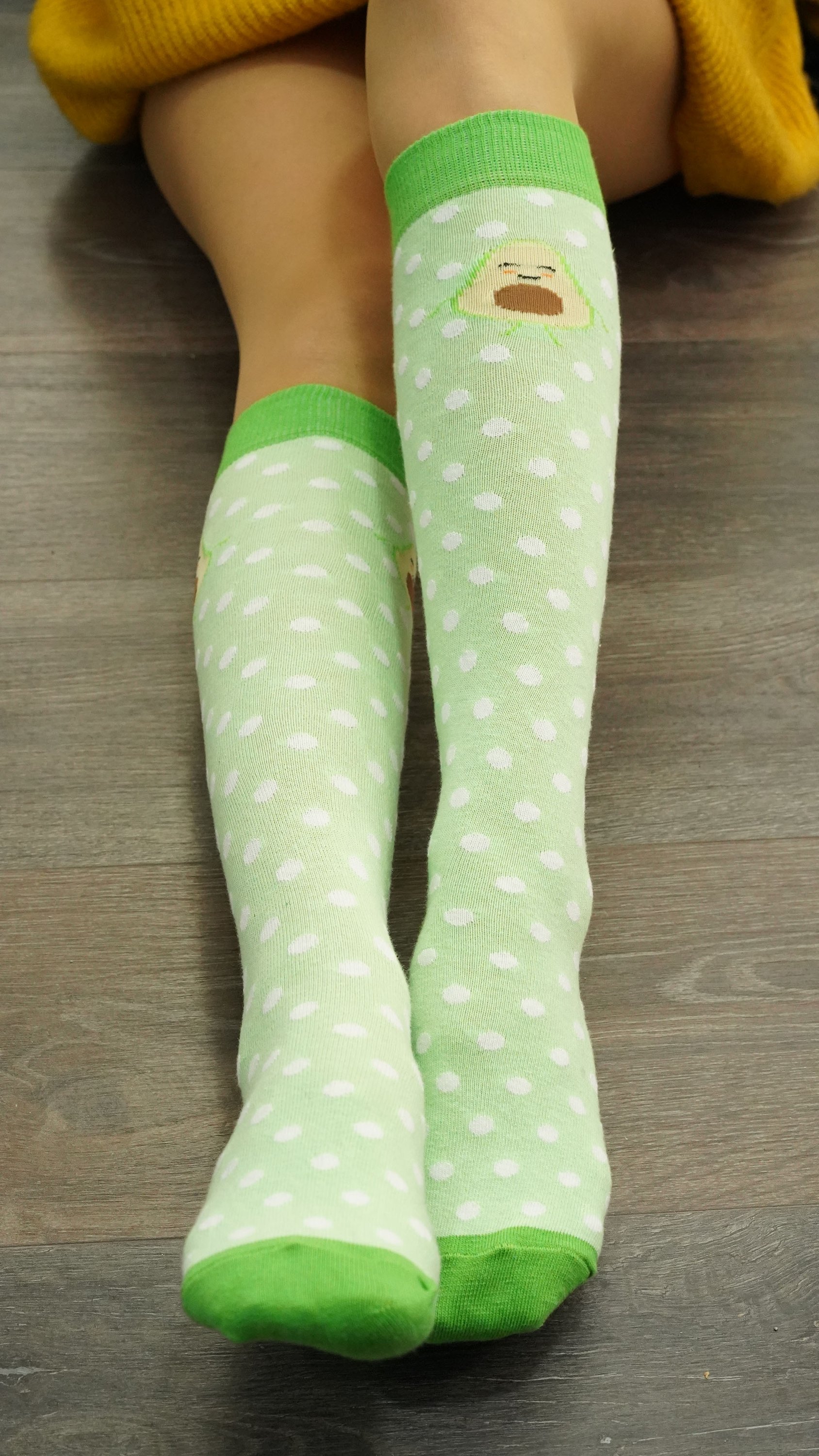 A pair of Women's Avocado Dot Knee High Socks featuring a colorful avocado dot pattern, perfect for adding a fun touch to any outfit.