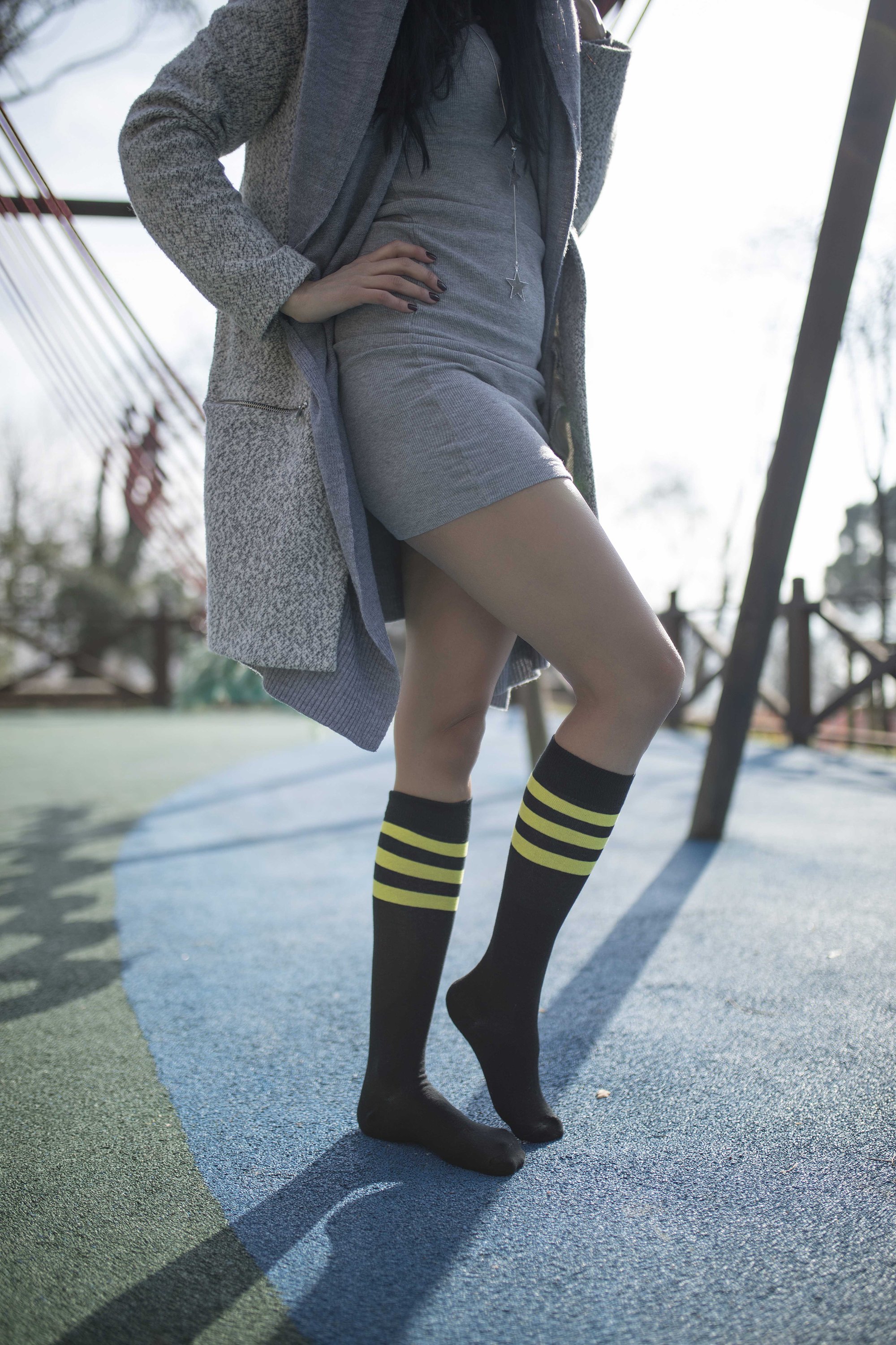 A pair of Women's Black Lemon Stripe Knee High Socks featuring a vibrant black and yellow striped design, perfect for adding style to any outfit.