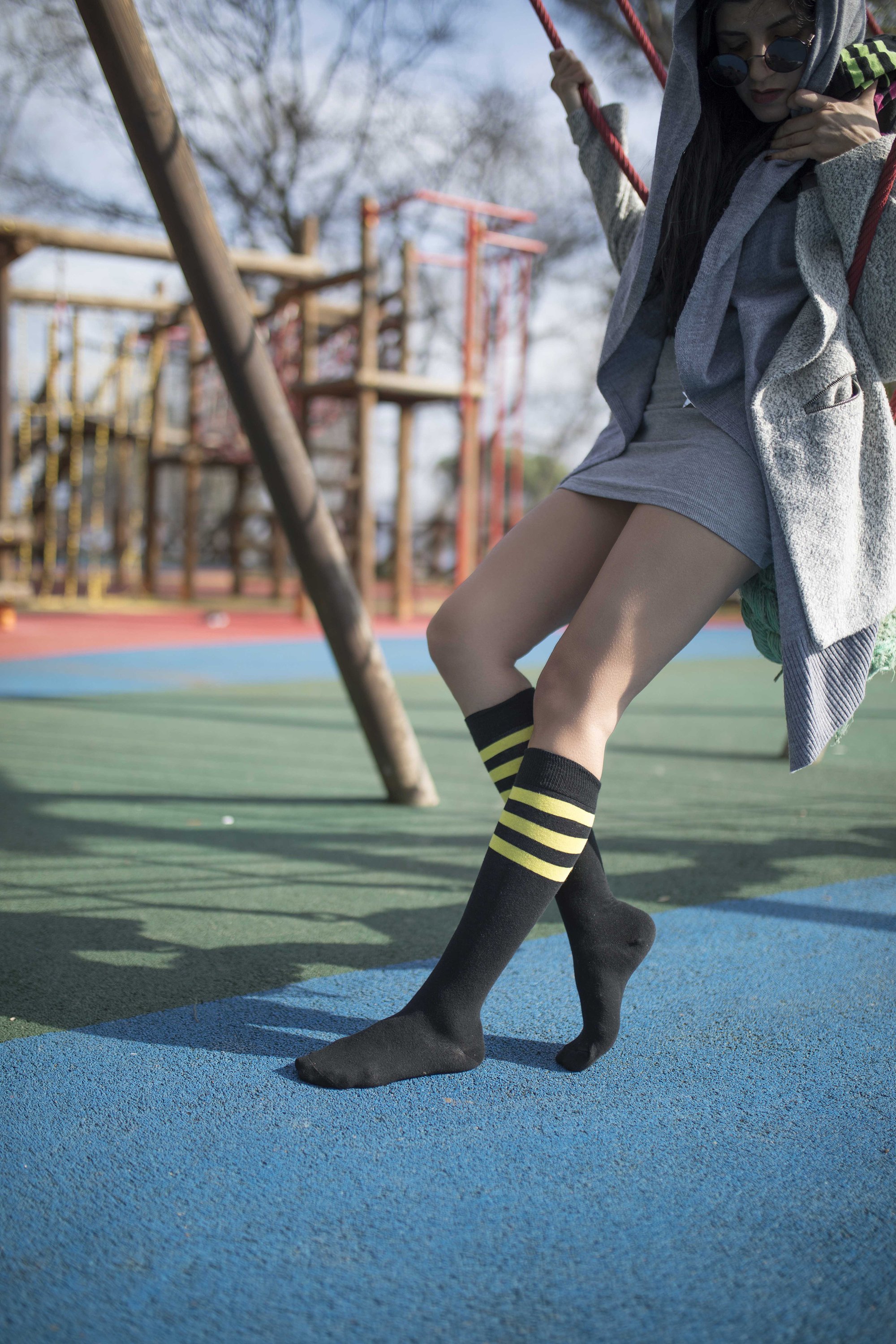 A pair of Women's Black Lemon Stripe Knee High Socks featuring a vibrant black and yellow striped design, perfect for adding style to any outfit.