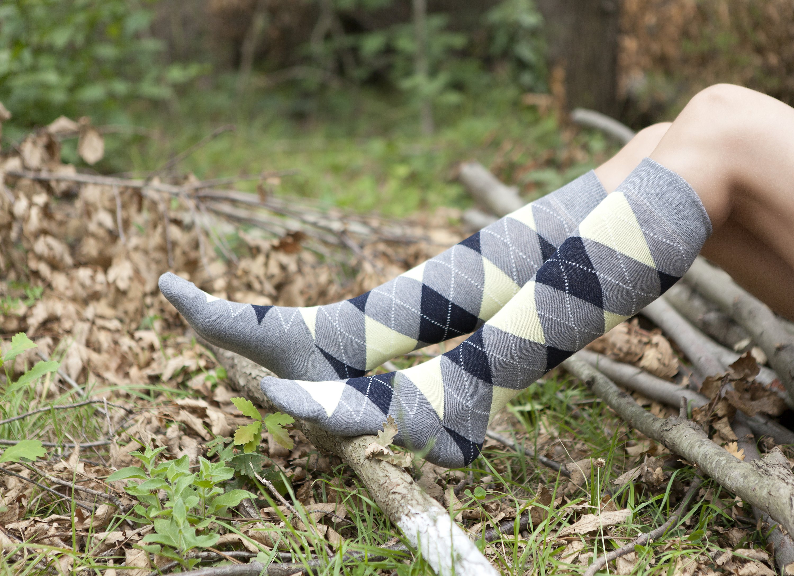 A pair of Women's Cloud Argyle Knee High Socks featuring vibrant colors and trendy patterns, perfect for adding style to any outfit.