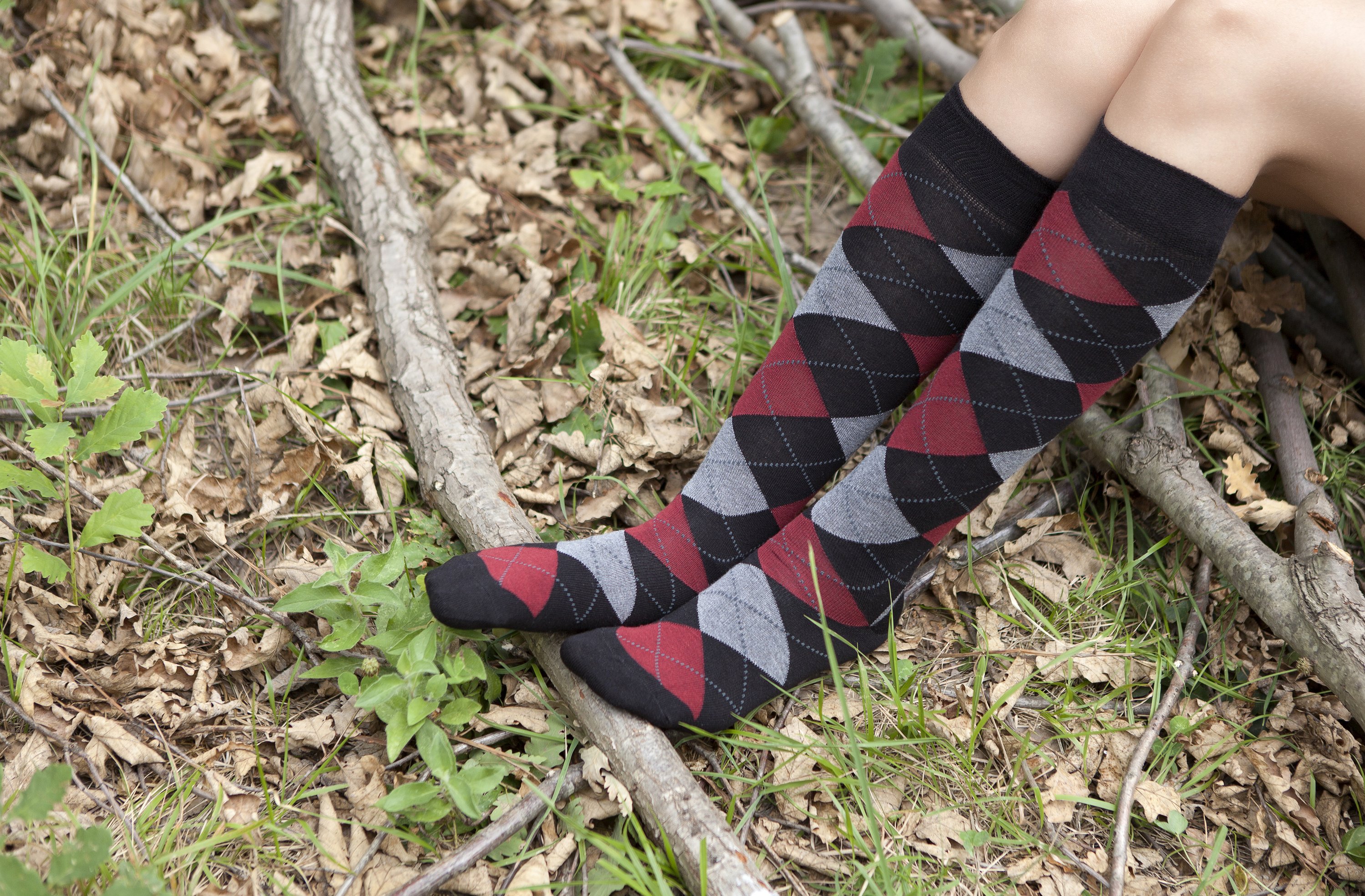 A pair of Women's Red Stone Argyle Knee High Socks featuring a vibrant argyle pattern, made from soft Turkish cotton for comfort and style.