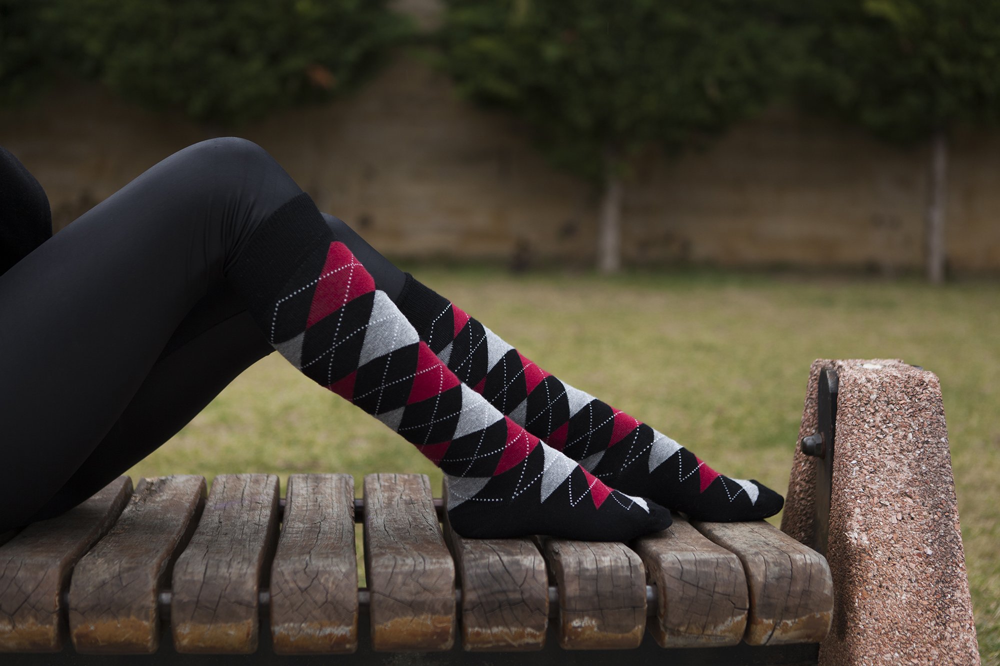 A pair of Women's Red Stone Argyle Knee High Socks featuring a vibrant argyle pattern, made from soft Turkish cotton for comfort and style.