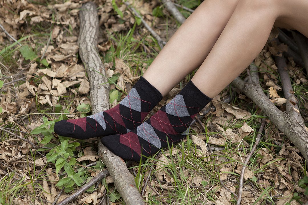 A pair of Women's Shiny Black Argyle Socks featuring a trendy design with a shiny finish, perfect for adding style to any outfit.