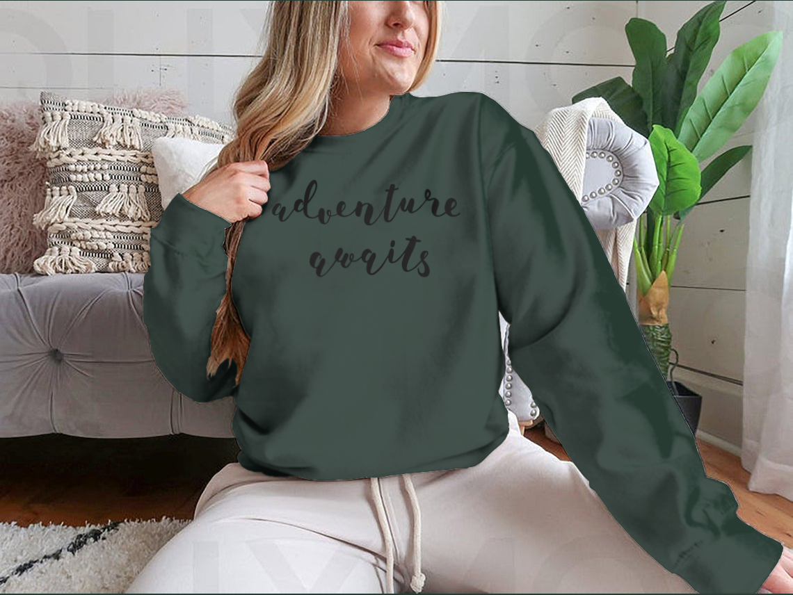 A stylish cotton-polyester blend shirt featuring the inspiring quote 'Adventure Awaits' in beautiful hand lettering, perfect for motivation.