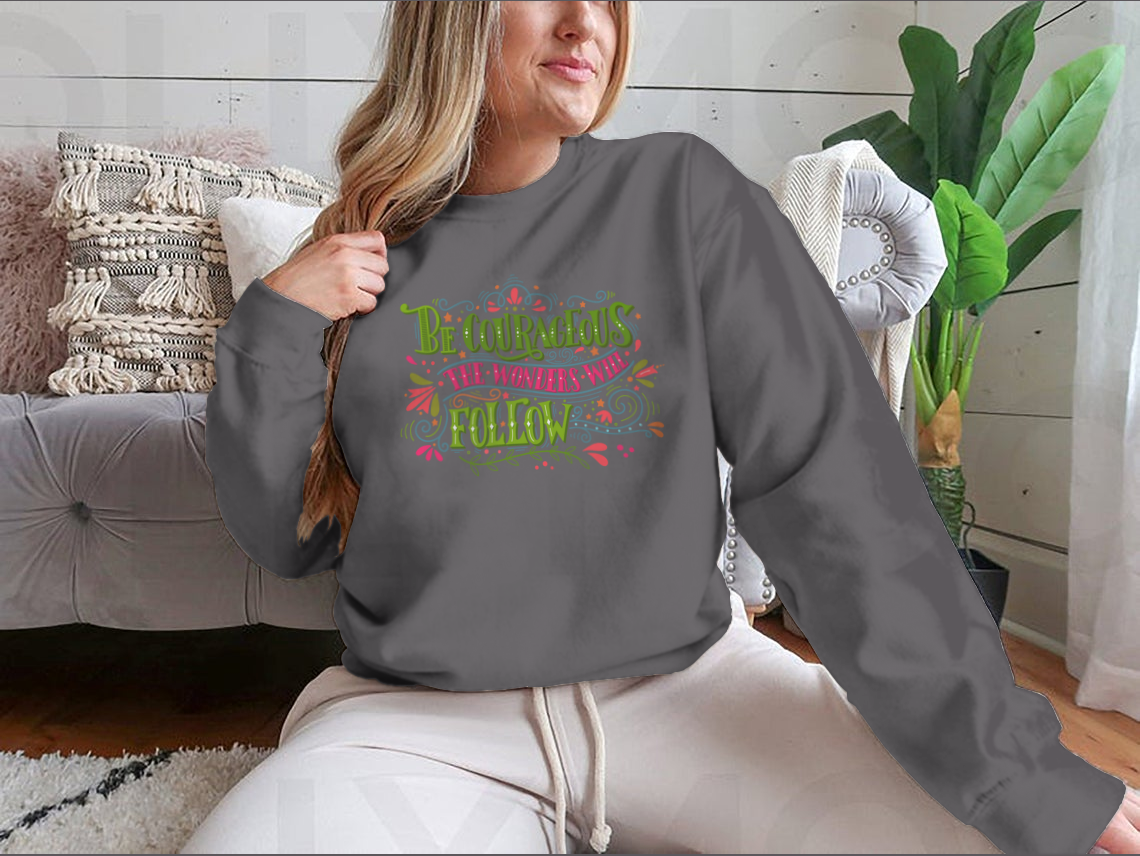 A motivational apparel piece featuring the phrase 'Be Courageous, The Wonders Will Follow' in a stylish design, made from a soft cotton/polyester blend.