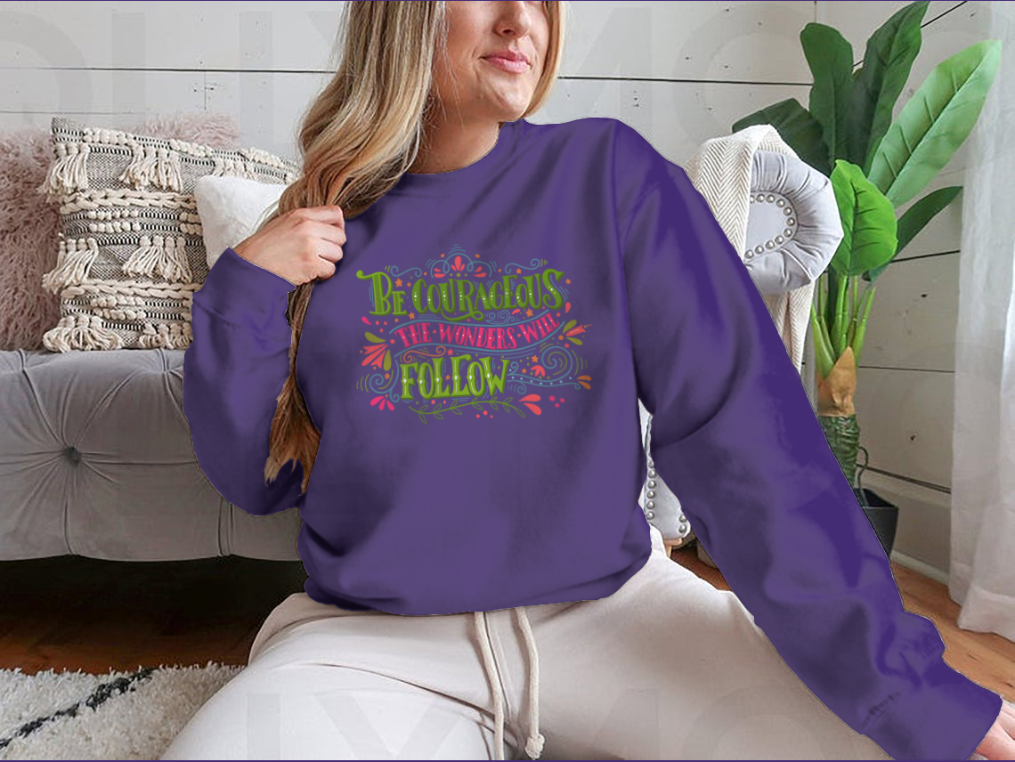 A motivational apparel piece featuring the phrase 'Be Courageous, The Wonders Will Follow' in a stylish design, made from a soft cotton/polyester blend.