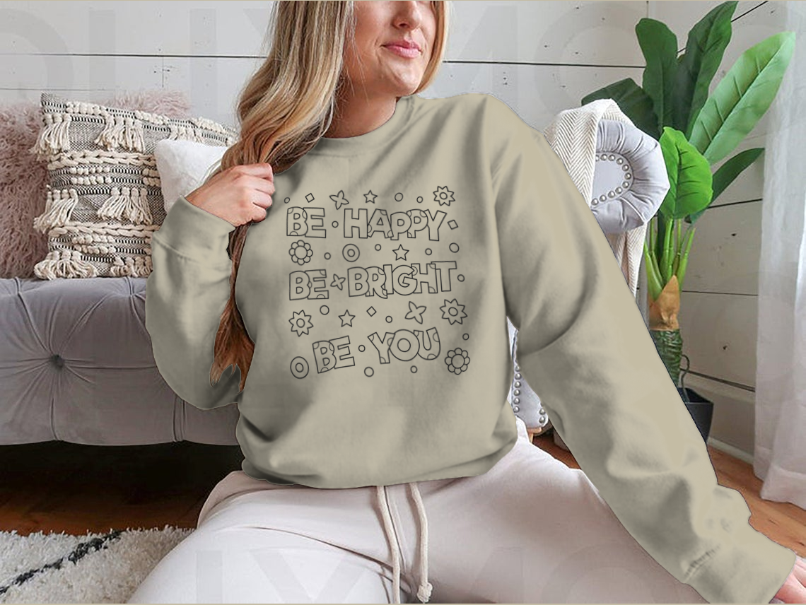 A cozy sweatshirt featuring an inspirational 'Be Happy Be Bright' design, perfect for casual wear.