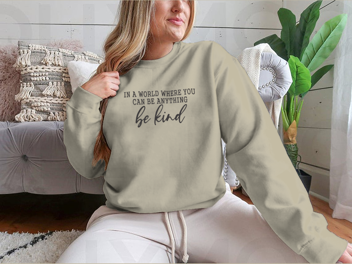 A stylish sweatshirt featuring a calligraphic design that reads 'Be Kind', made from soft cotton fabric.