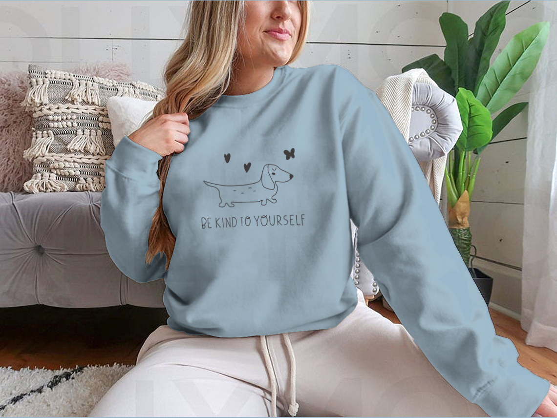 A cozy sweatshirt featuring the inspirational phrase 'Be Kind To Yourself' in a stylish design, perfect for casual wear.