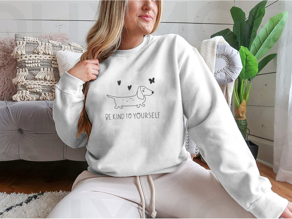 A cozy sweatshirt featuring the inspirational phrase 'Be Kind To Yourself' in a stylish design, perfect for casual wear.