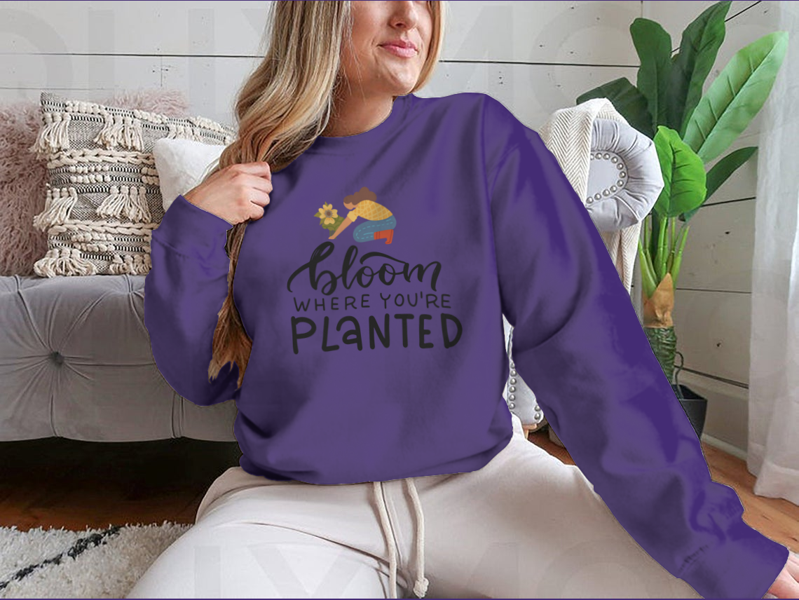 A stylish t-shirt featuring the hand-drawn quote 'Bloom Where You Are Planted' in elegant lettering.