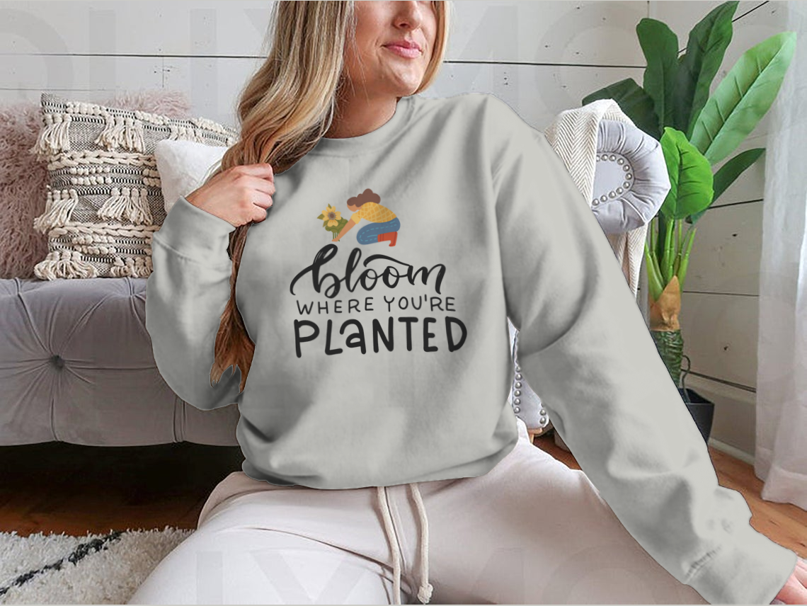 A stylish t-shirt featuring the hand-drawn quote 'Bloom Where You Are Planted' in elegant lettering.