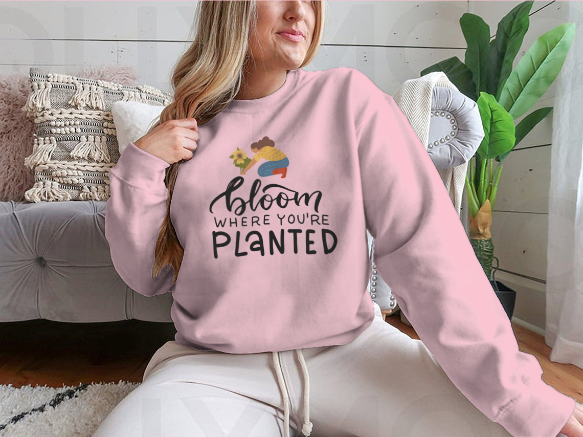 A stylish t-shirt featuring the hand-drawn quote 'Bloom Where You Are Planted' in elegant lettering.