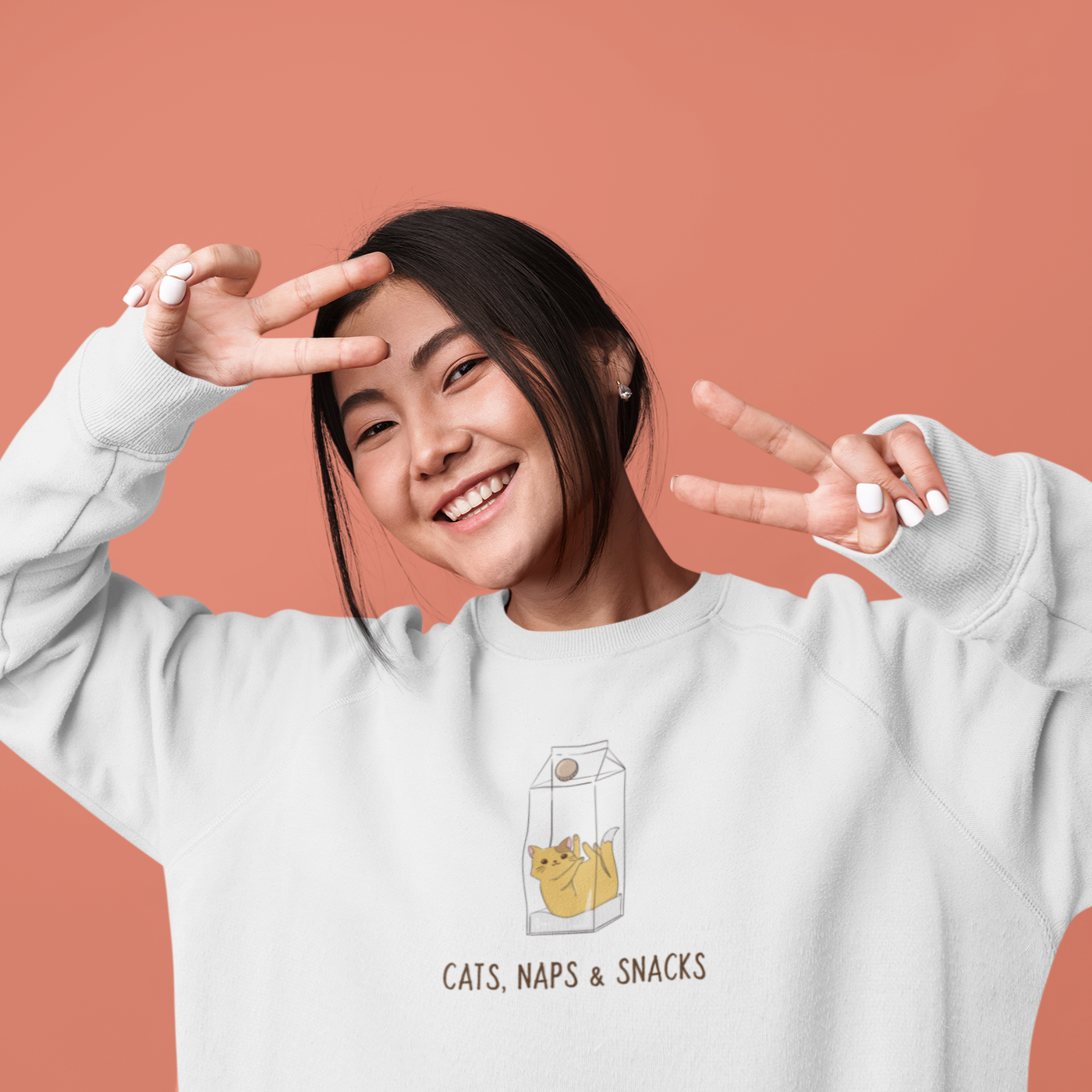 A cozy organic unisex sweatshirt featuring the phrase 'Cats, Naps & Snacks', made from eco-friendly materials.