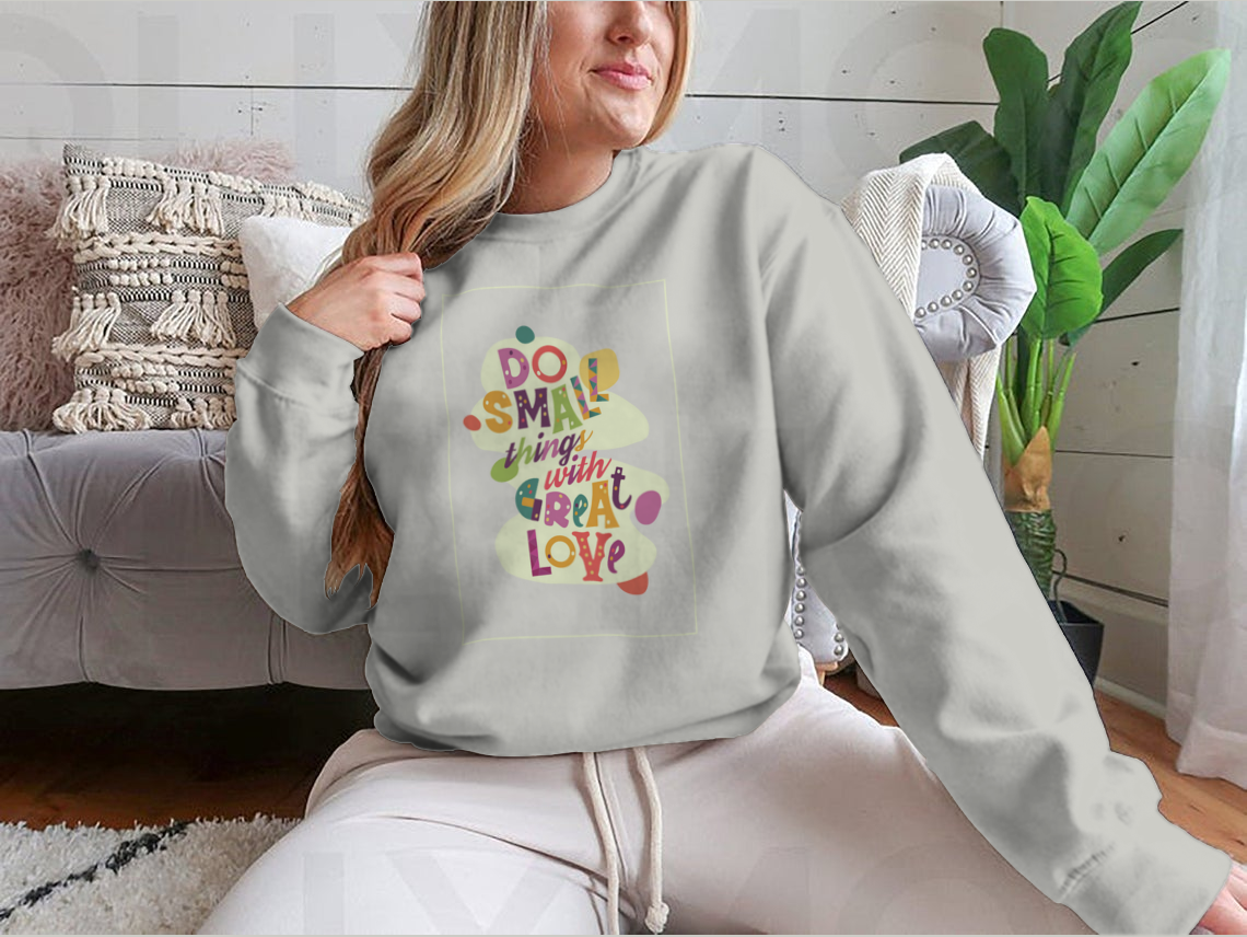 A cozy sweatshirt featuring the inspirational quote 'Do Small Things With Great Love', showcasing a classic fit and soft fabric.