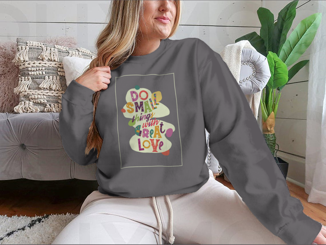 A cozy sweatshirt featuring the inspirational quote 'Do Small Things With Great Love', showcasing a classic fit and soft fabric.