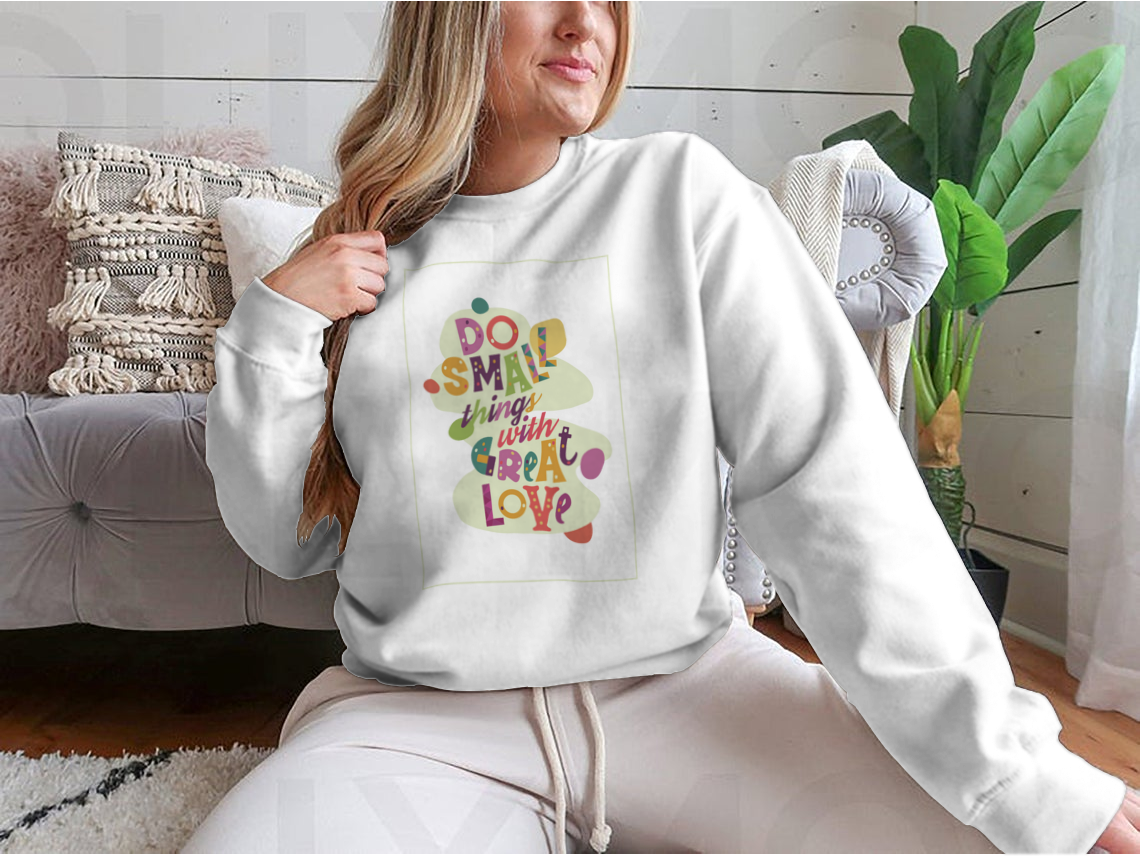 A cozy sweatshirt featuring the inspirational quote 'Do Small Things With Great Love', showcasing a classic fit and soft fabric.